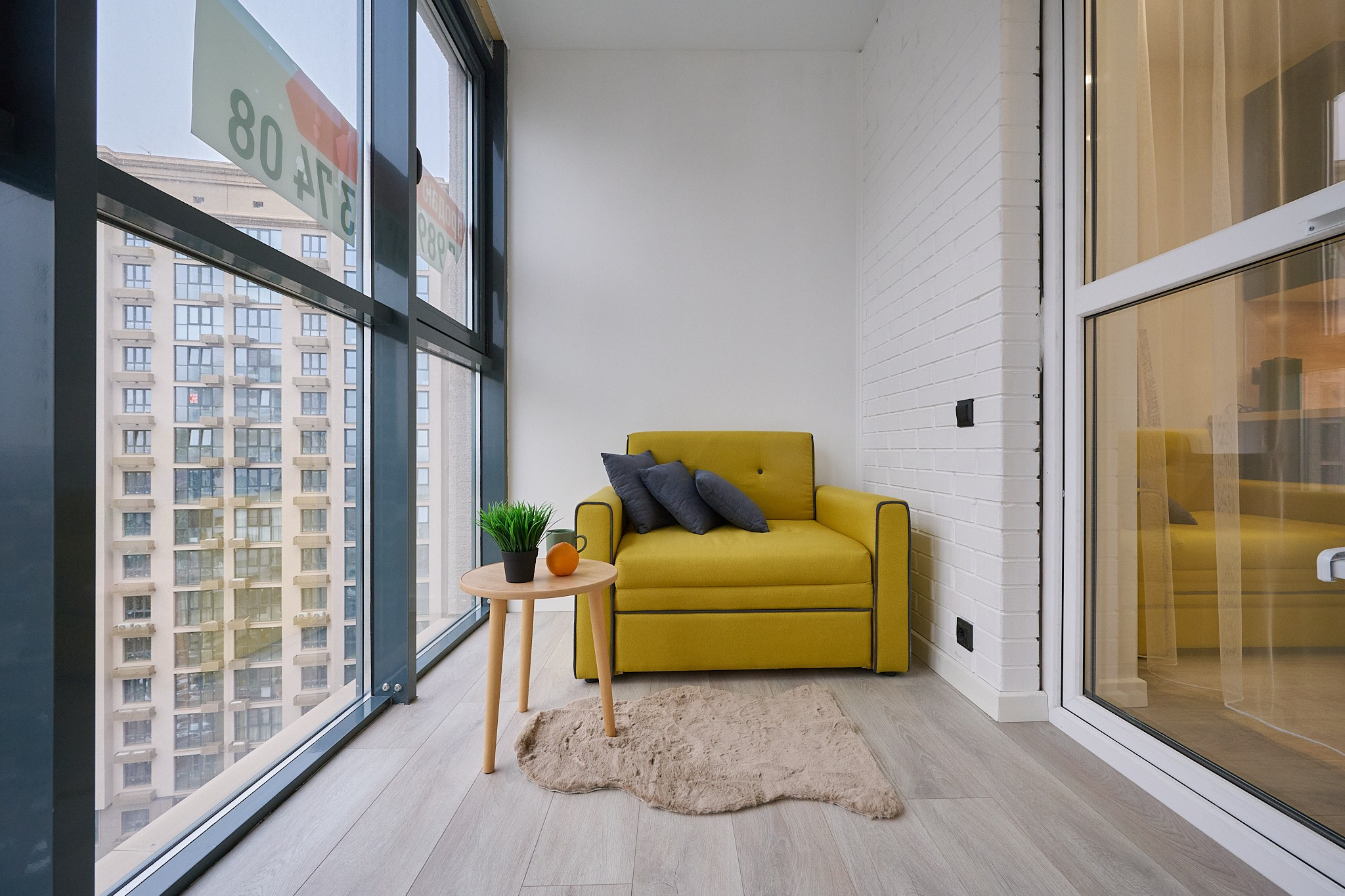 балкон с окнами до пола желтым диваном большой балкон 