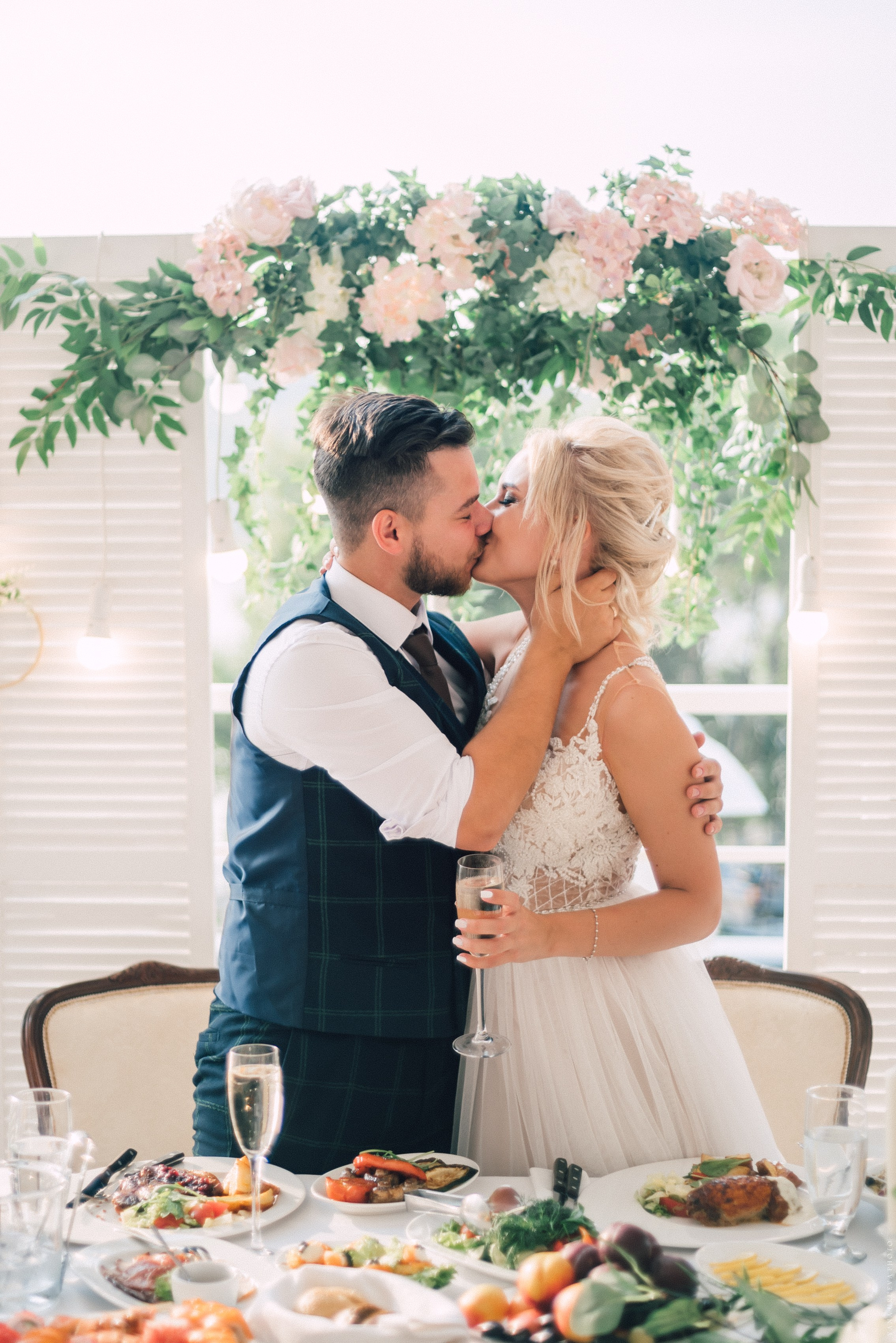 Молодожены целуются на банкете