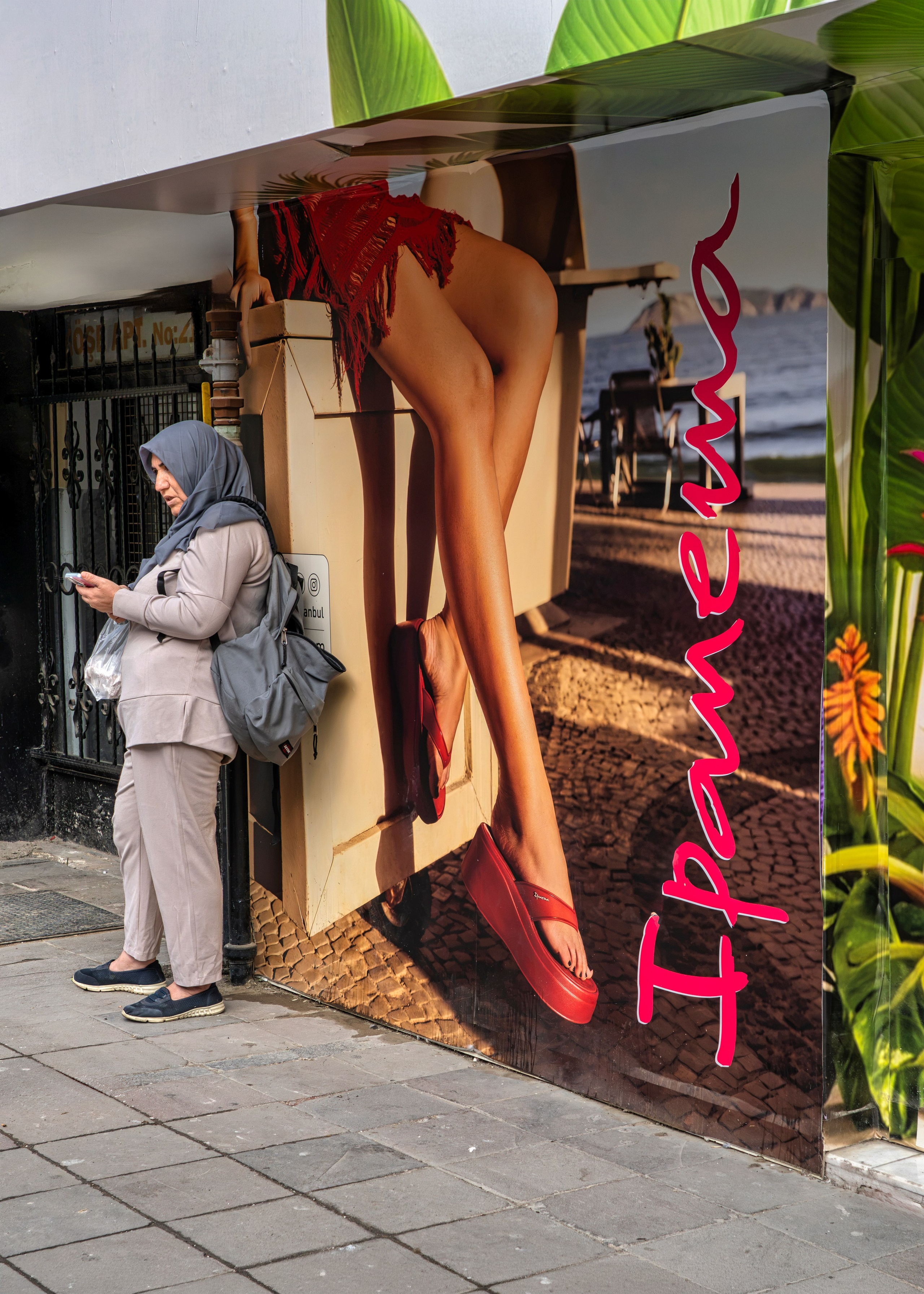 Woman in a hijab and an advertisement in one frame, Izmir, street photography.