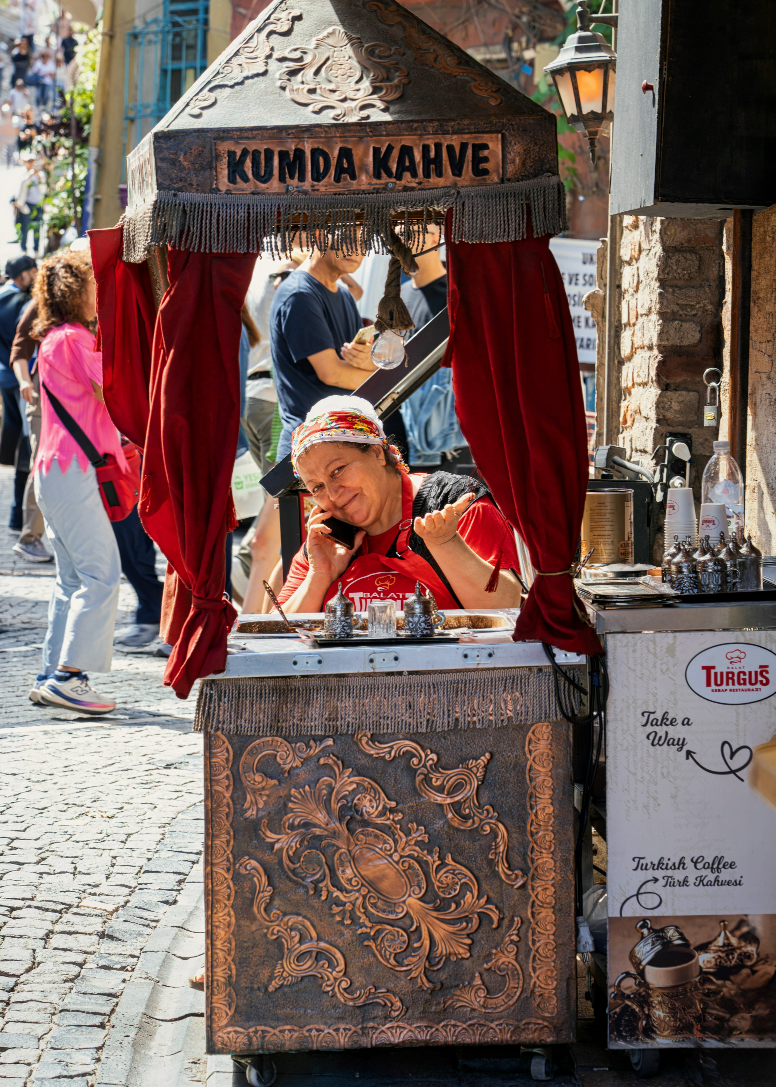 Turkish coffee vendor on a street in Istanbul, "Kumda Kahve" sign, street photography.