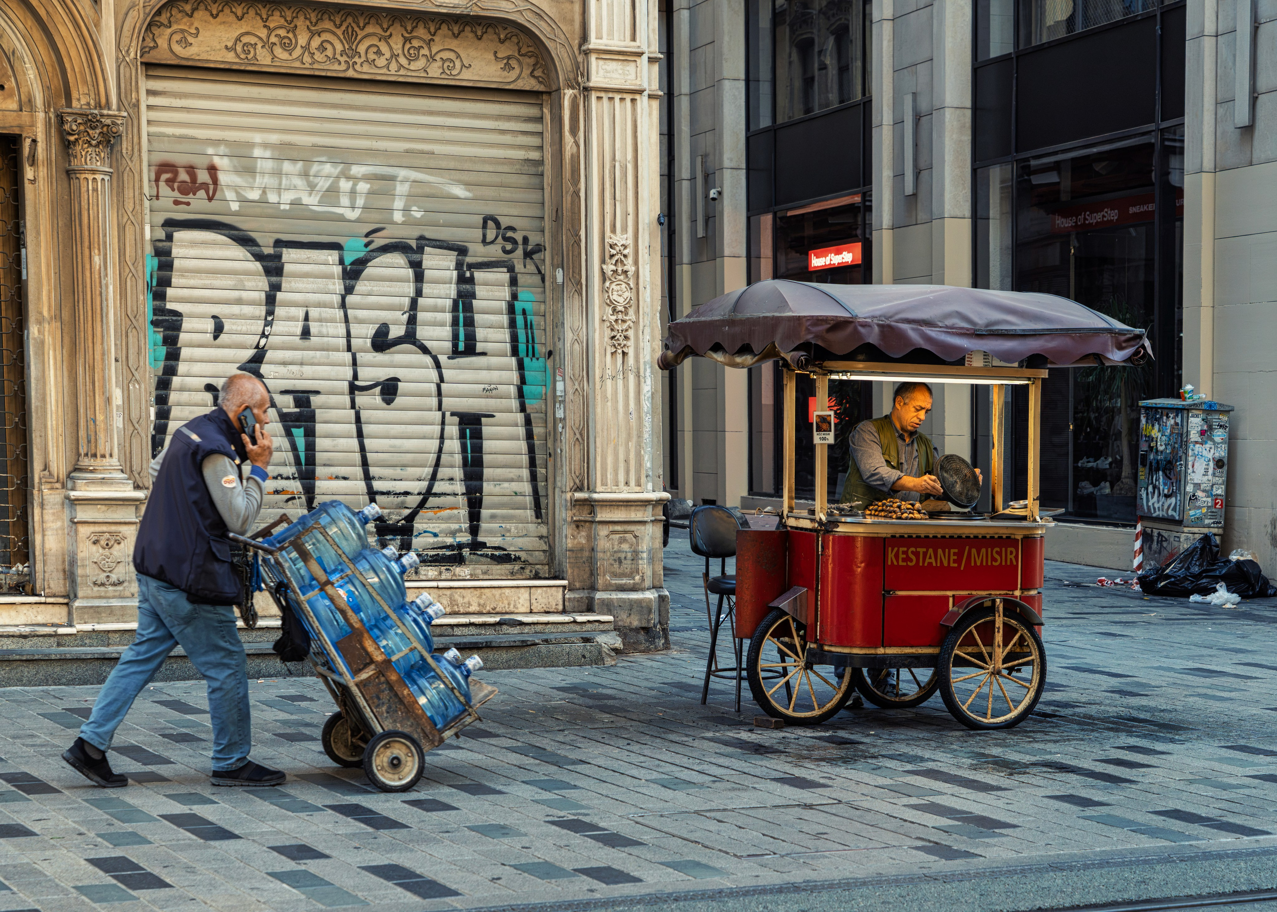 Early morning on Istiklal Street in Istanbul, chestnut and corn vendor, water seller, street photography.