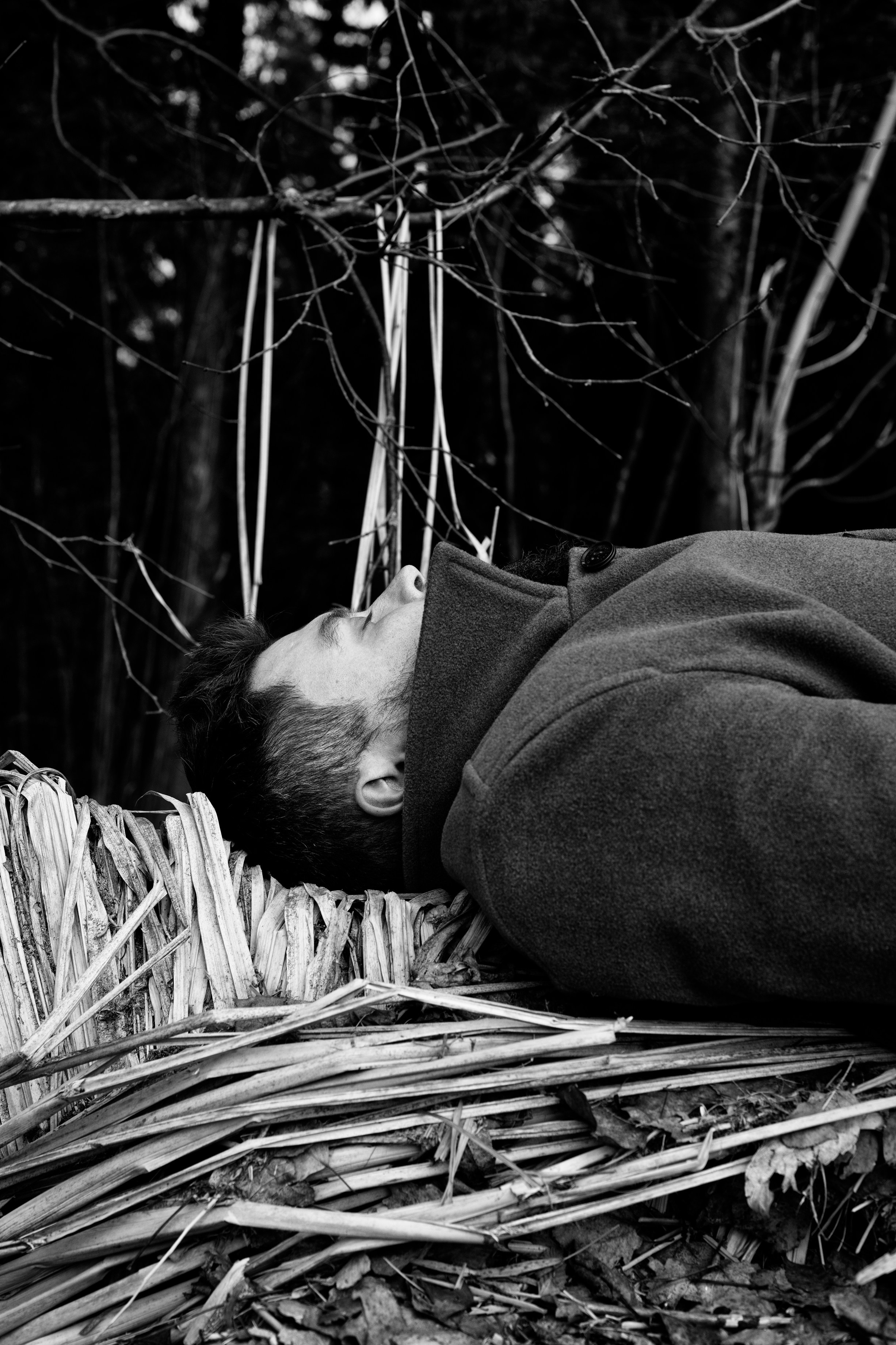 Мужской портрет, мужчина в пальто лежит на берегу озера