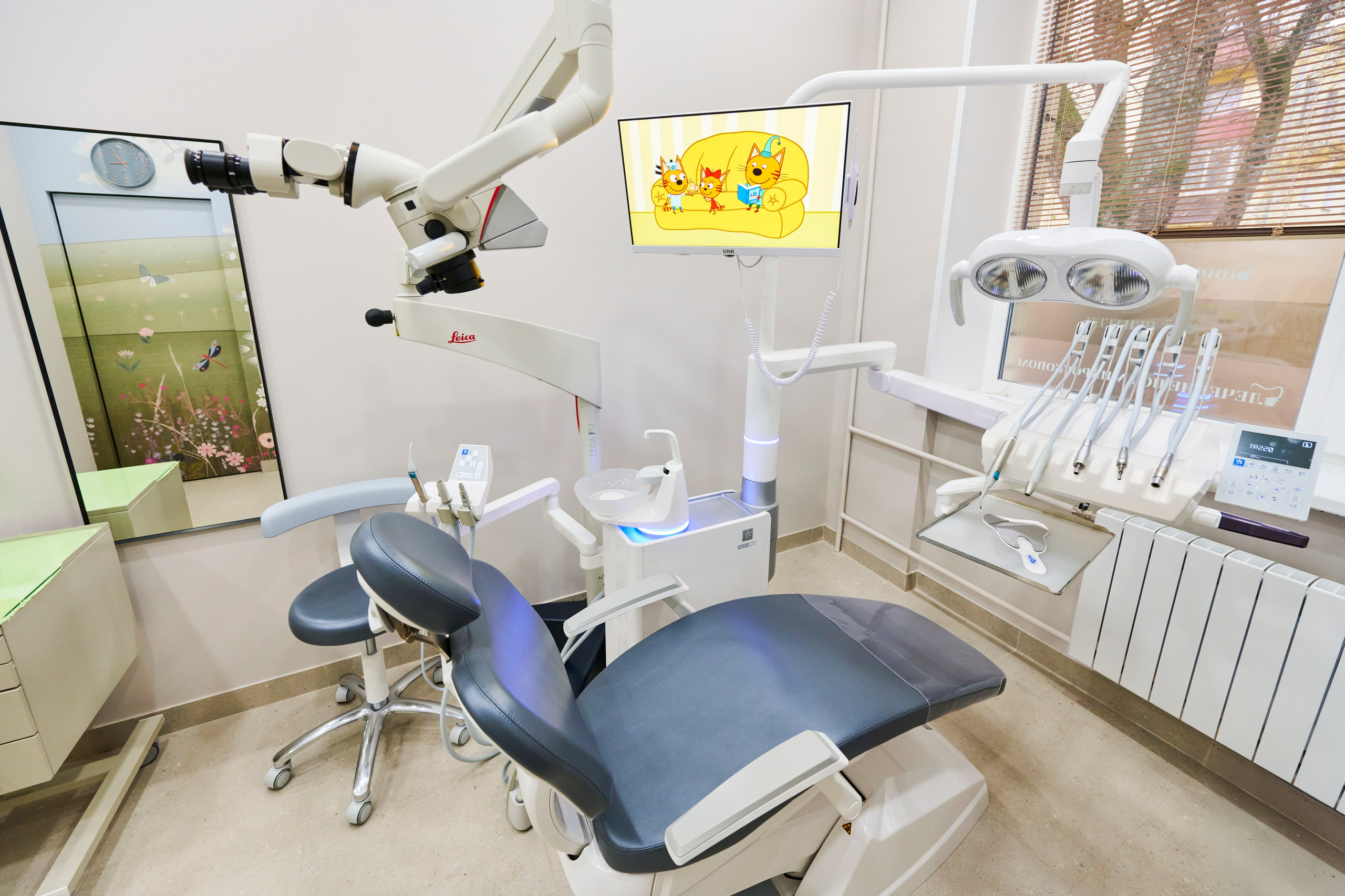 Кабинет стоматолога: кресло, монитор, столик ассистента, нейтральные тона