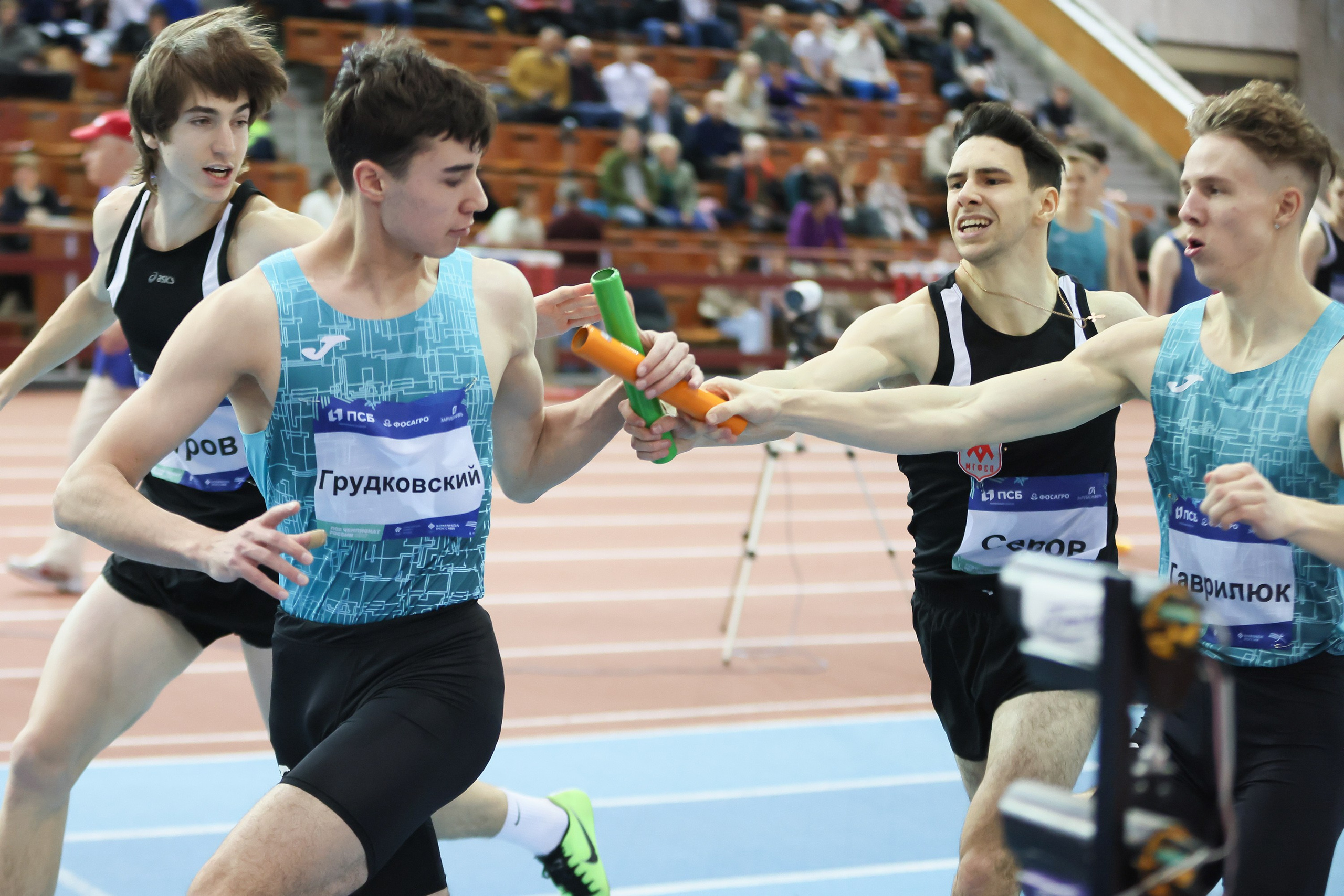 Бегуны мужчины передают эстафету