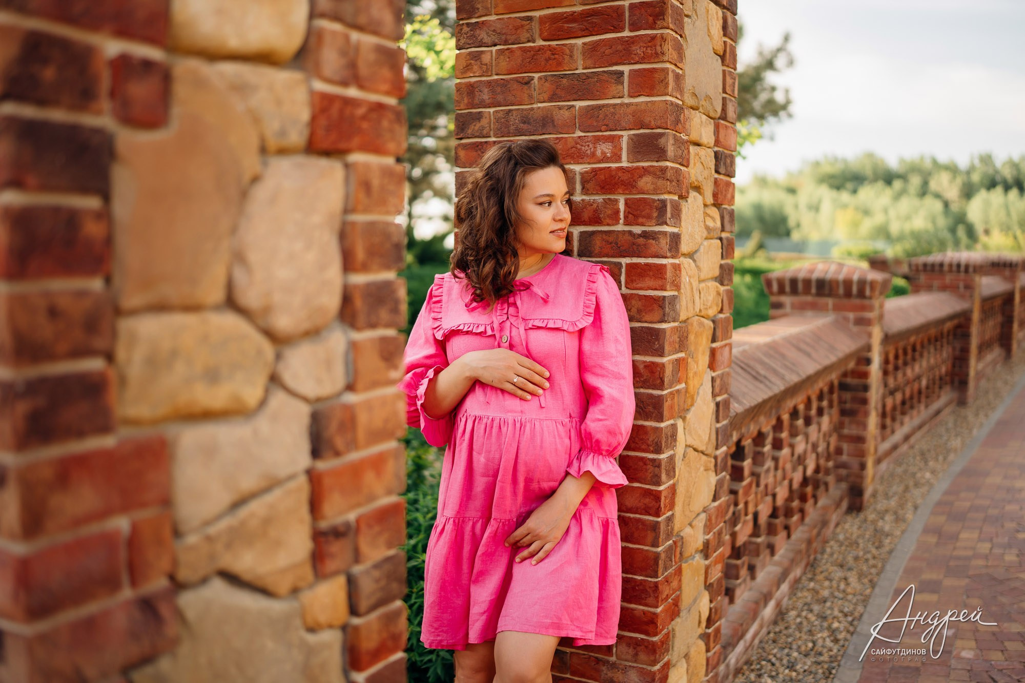 Фотосессия беременности в Олд Хаус | Беременная обнимает живот на фоне каменного забора в старинном стиле | Фотограф Андрей Сайфутдинов Ростов-на-Дону