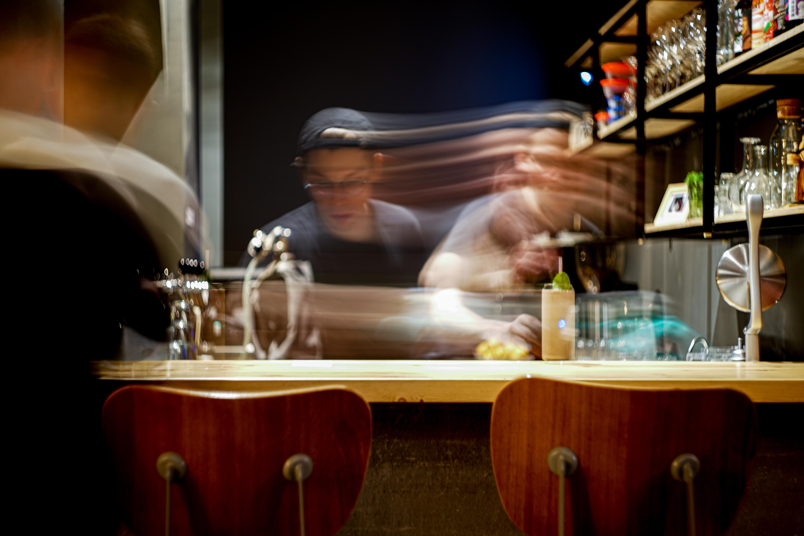 барная стойка с барменом наливает фотография на длинную выдержку
