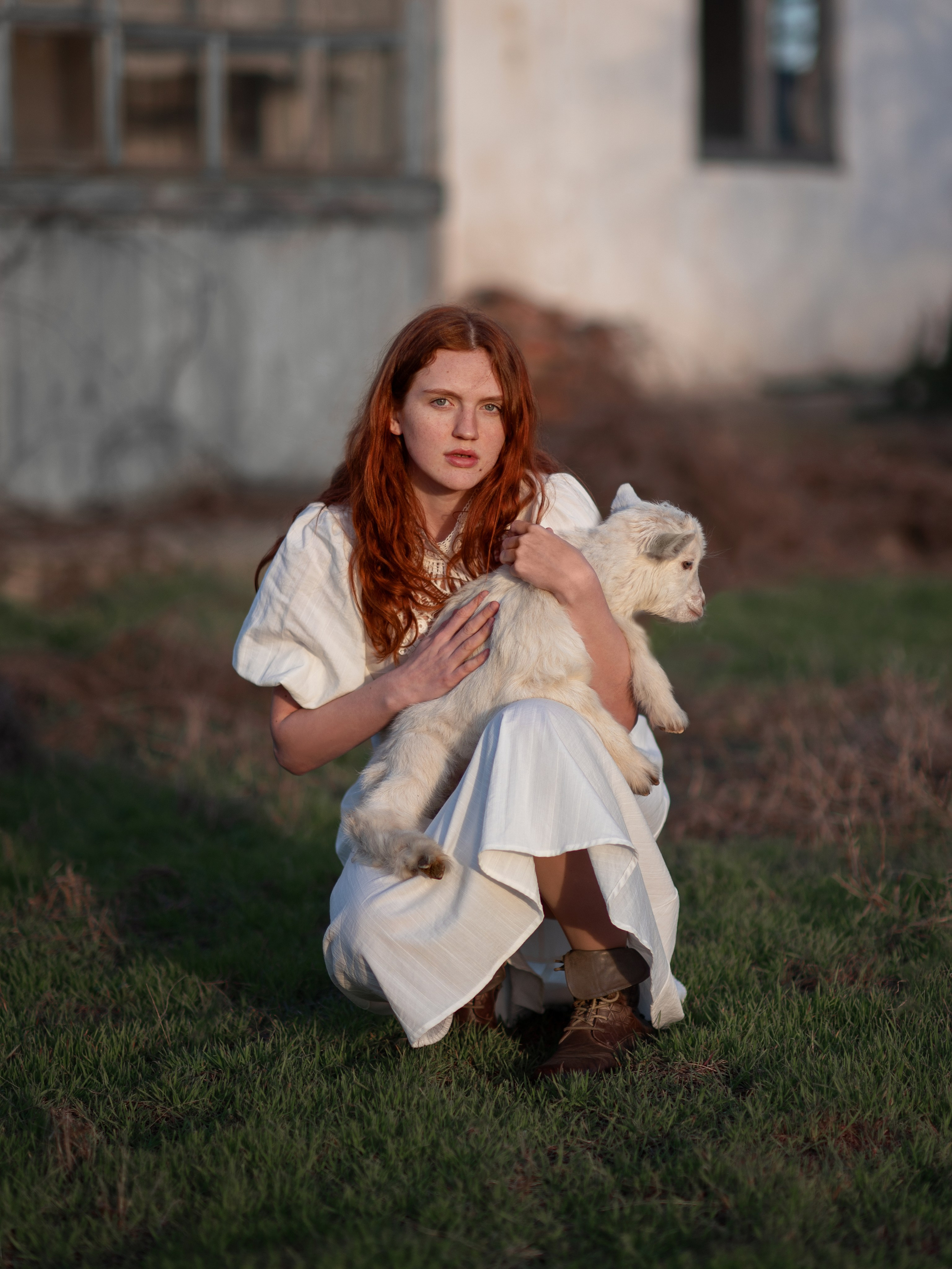 Девушка с козленком у деревенского домика