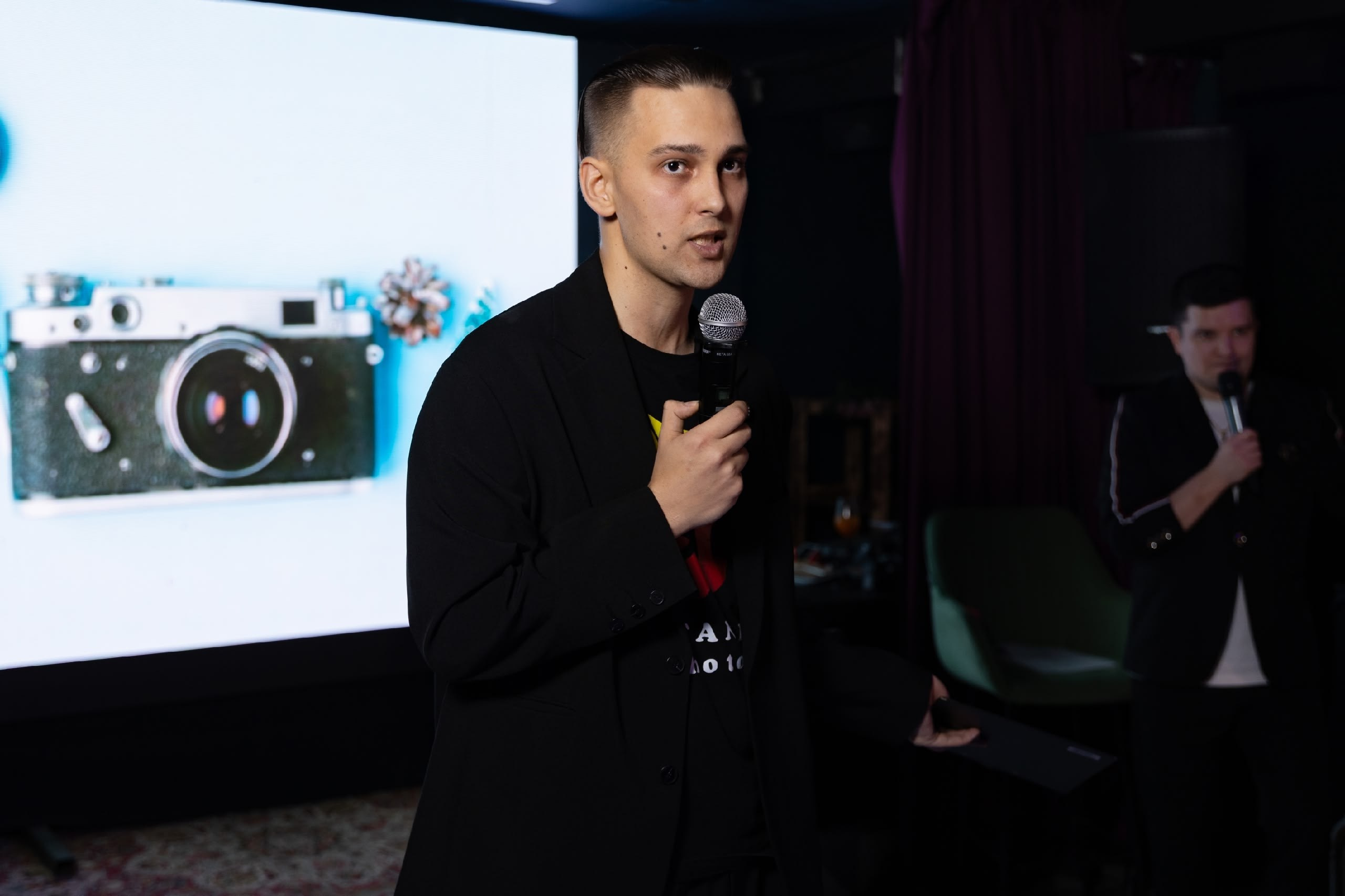 Фотограф Евгений Потанин, с микрофоном в руках выступает перед другими фотографами, город Ижевск