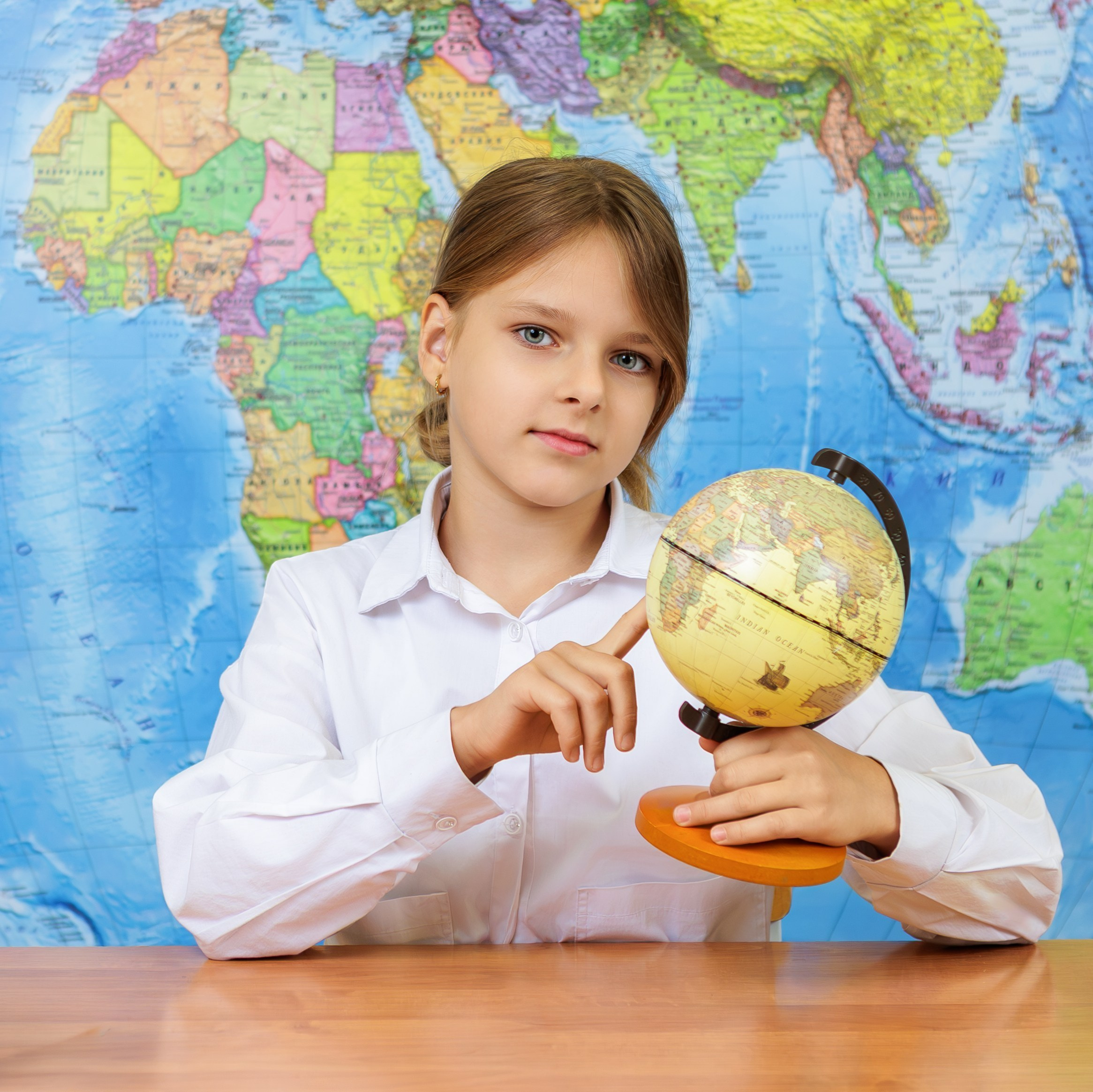Девочка с глобусом на столе, портрет школьника