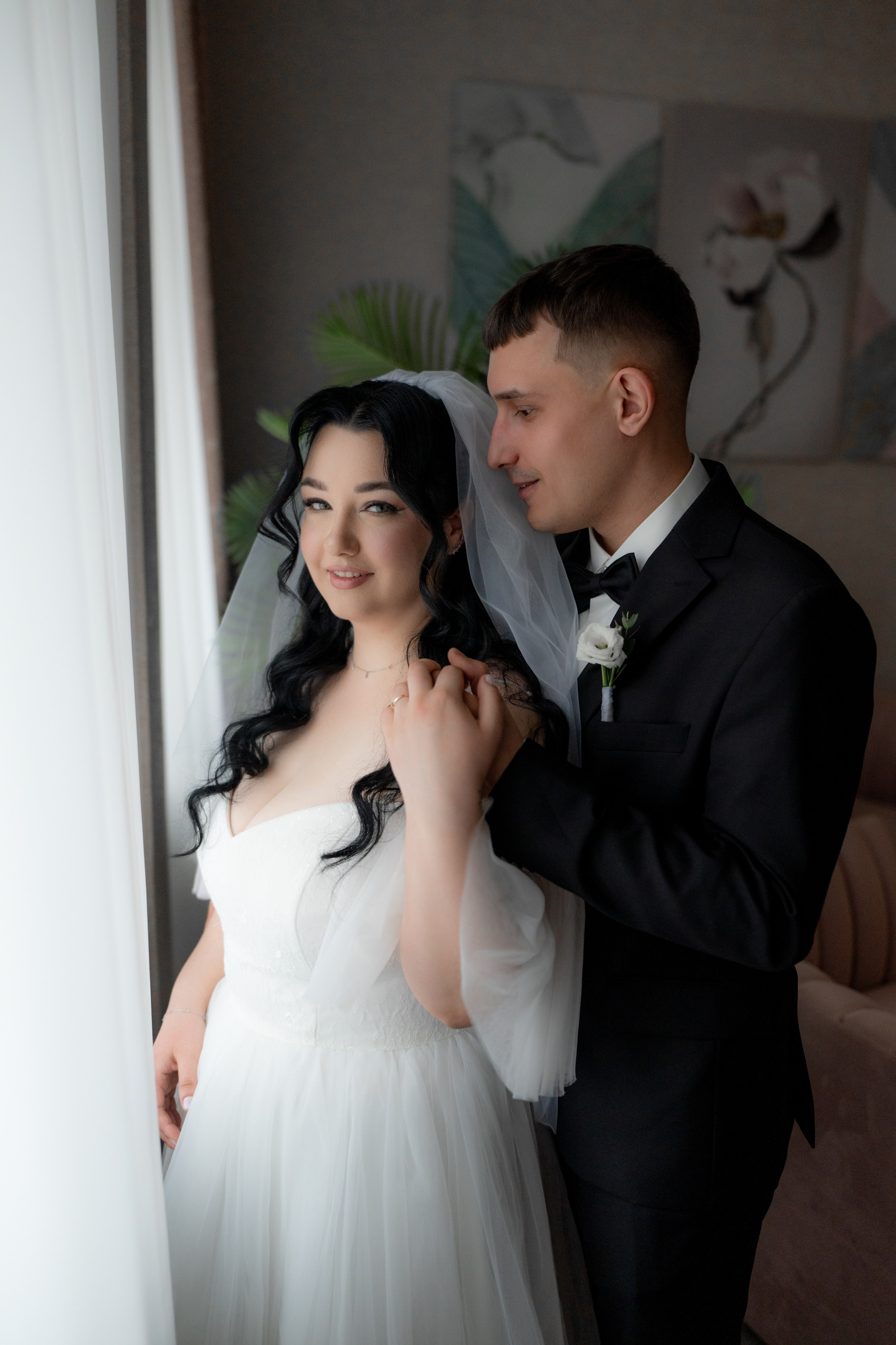 Свадебная фотосессия  в загсе Фрунзенского района на проспекте Славы в Санкт Петербурге жених и невеста в комнате жениха у окна