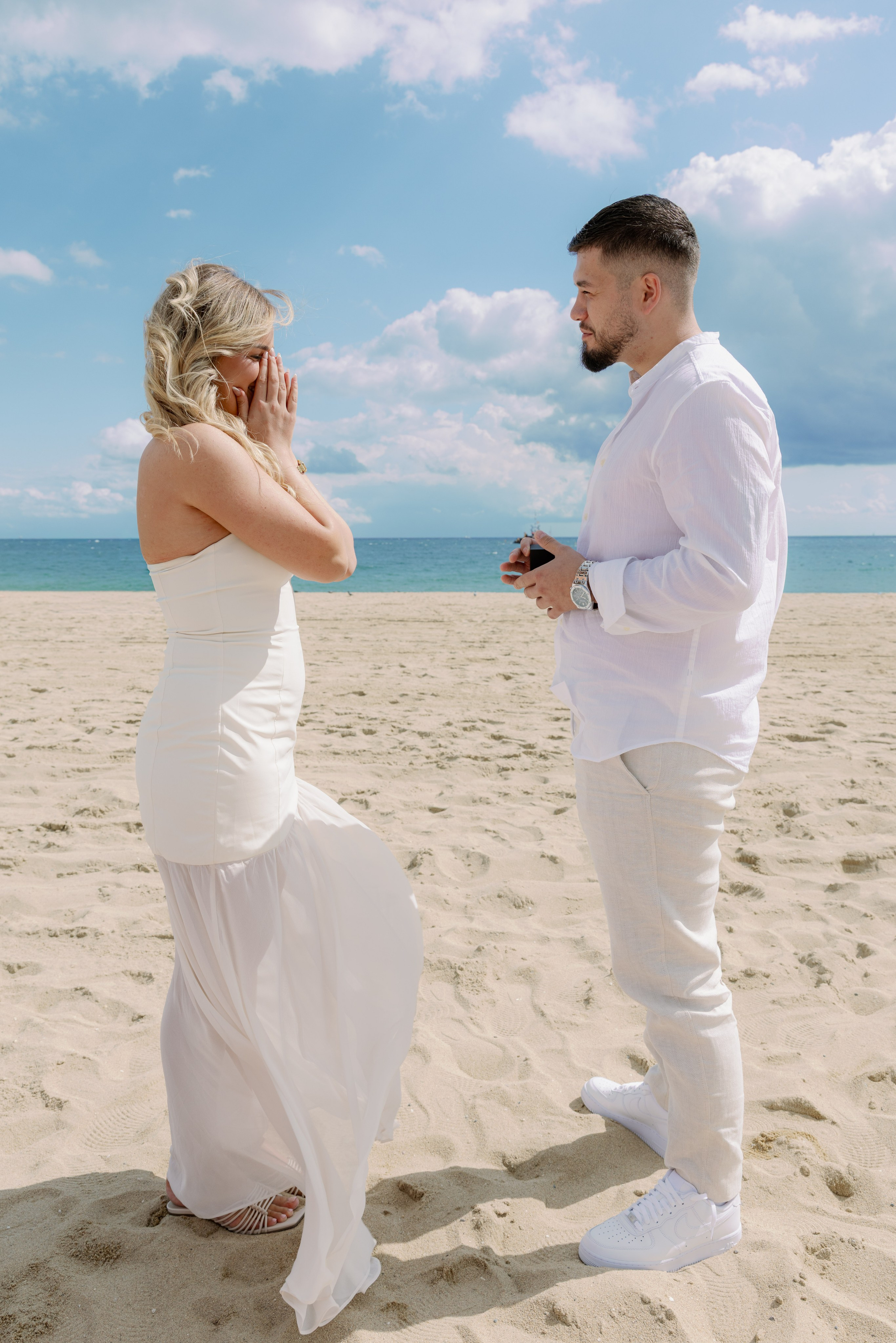 Man on one knee proposing by the beach in Barceloneta