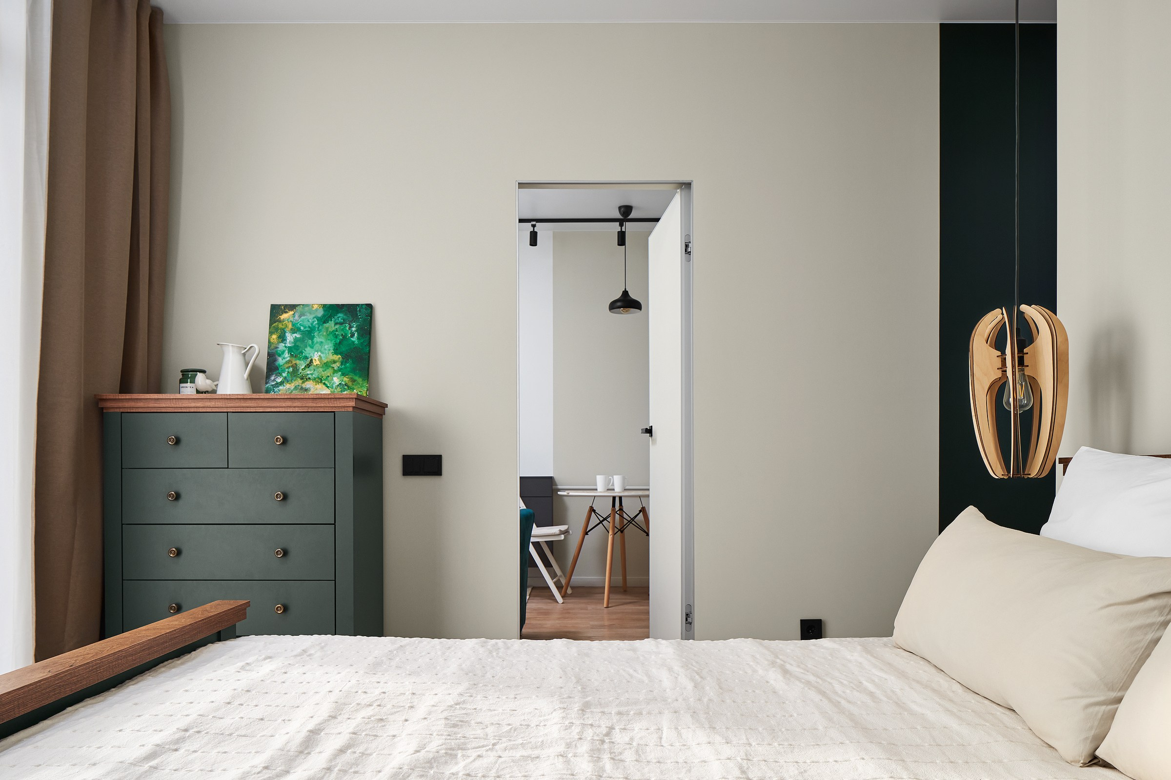 Кровать в небольшой современной квартире, дверь на кухню.