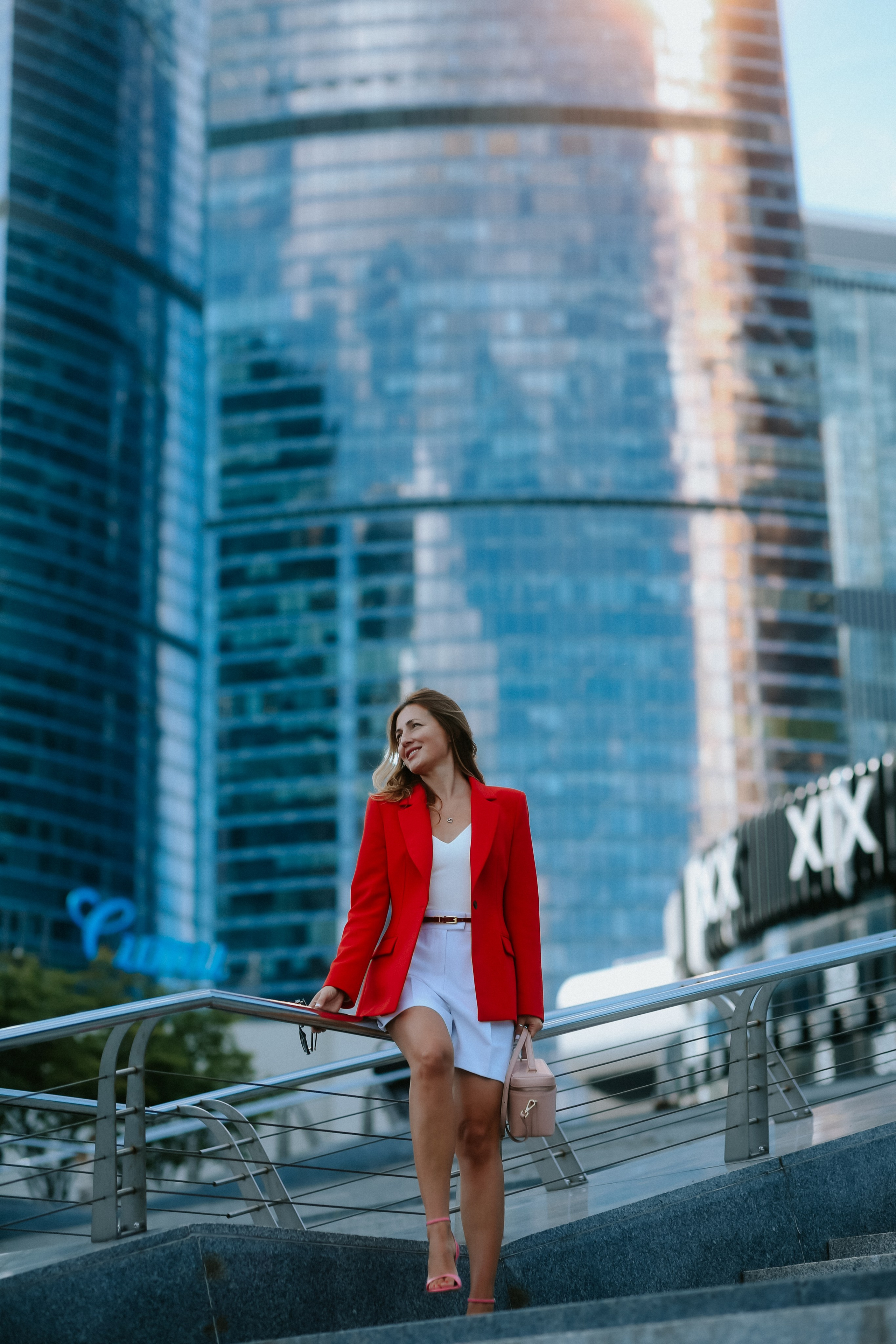 <img src="IZ0A0352.jpg" alt="Бизнес-леди в в ярком красном пиджаке и белых шортах позирует на фоне небоскрёбов Москва-Сити">