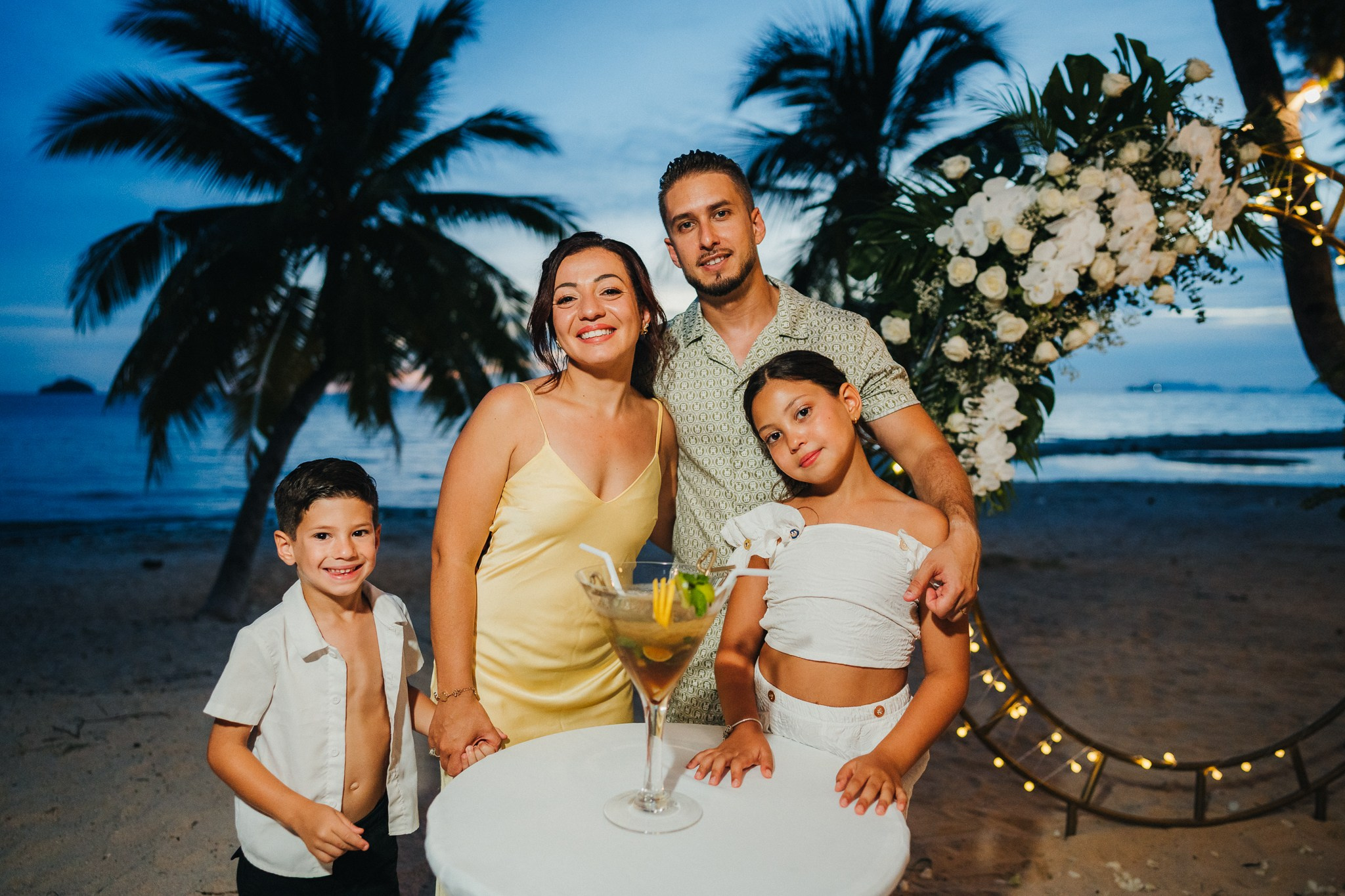 Intimate family wedding on the beach in Koh Samui, Thailand with the couple and their children enjoying the ceremony together