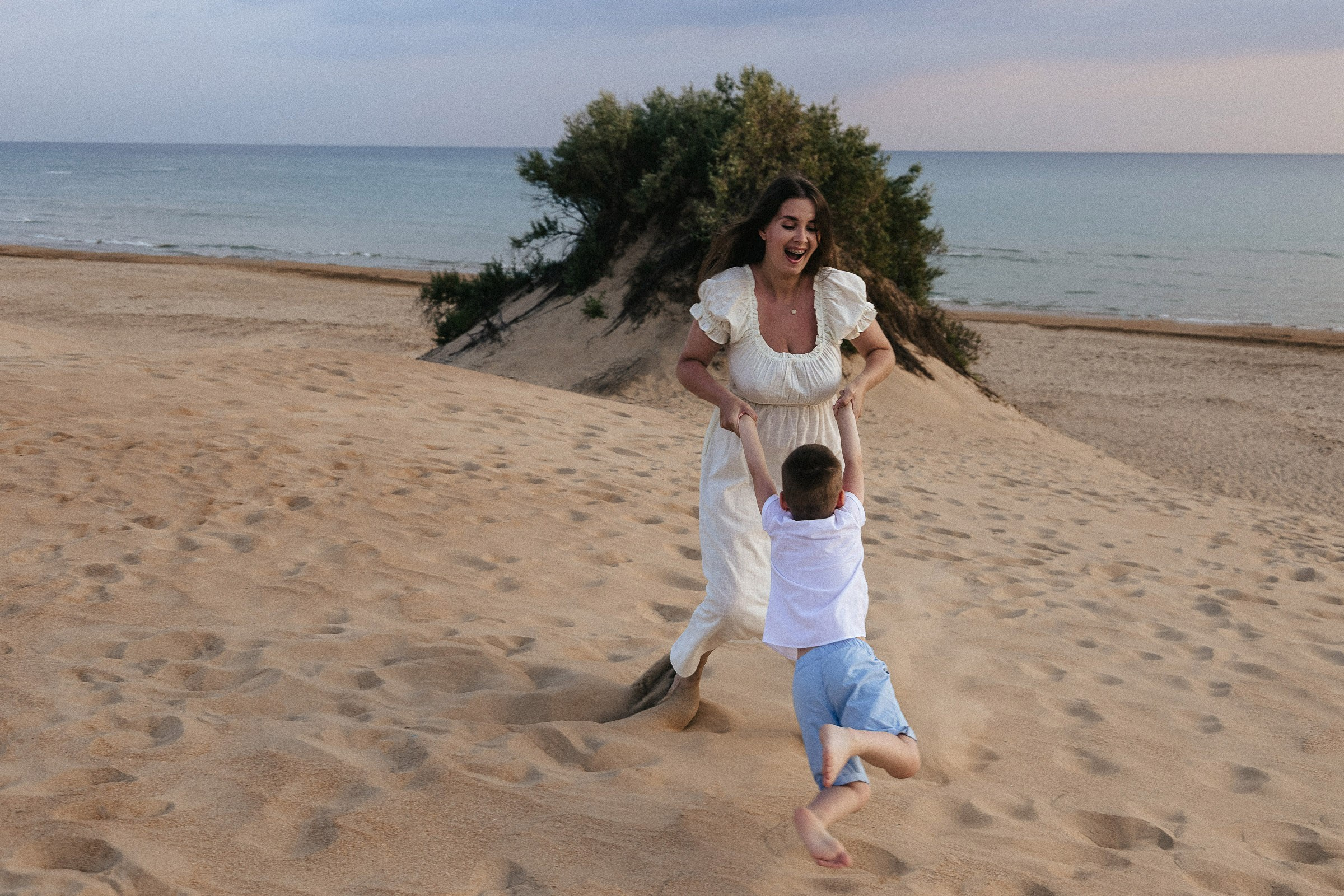 мама и сын на пляже играют