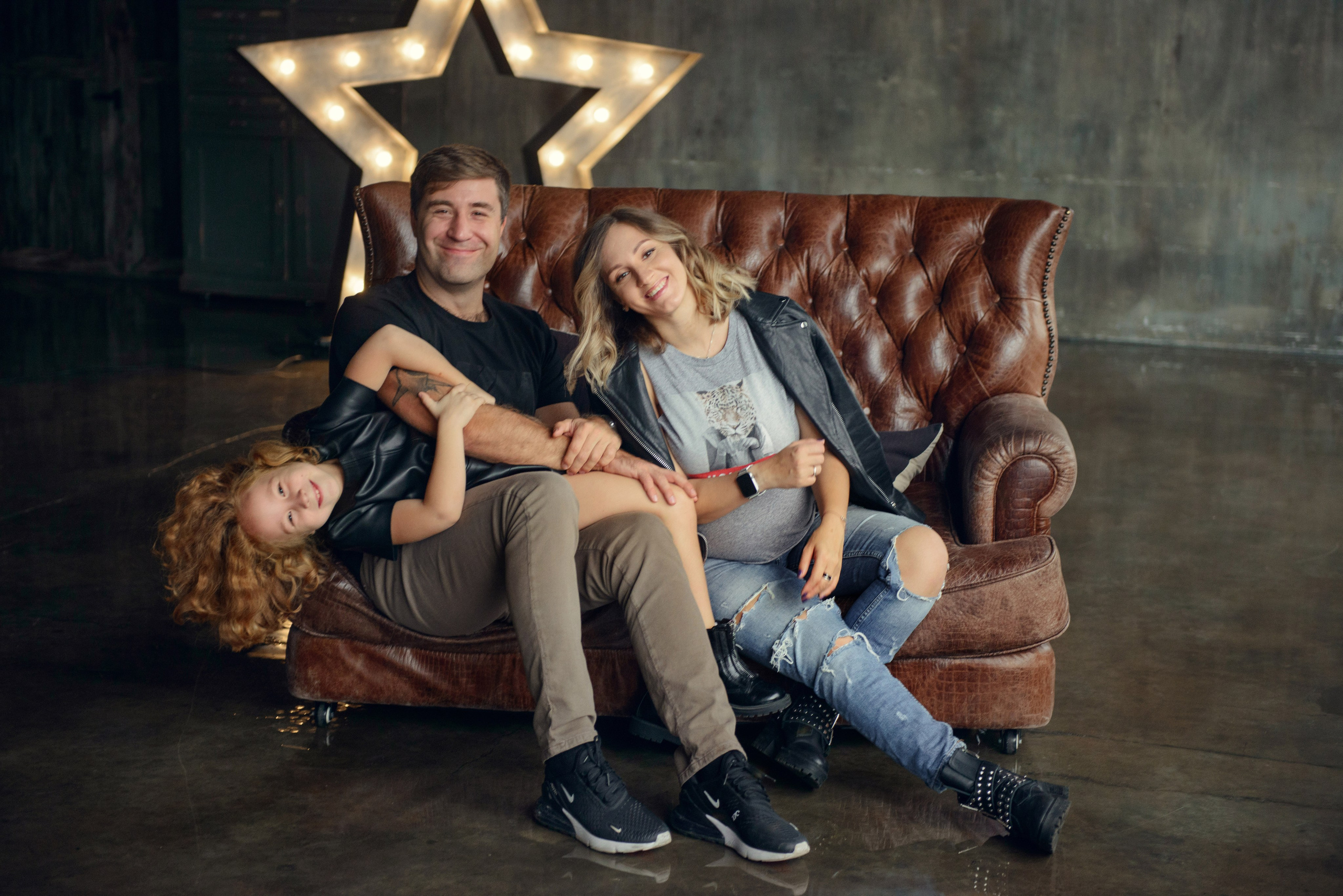 Family photo shoot with a pregnant woman in a loft studio, rock and roll style