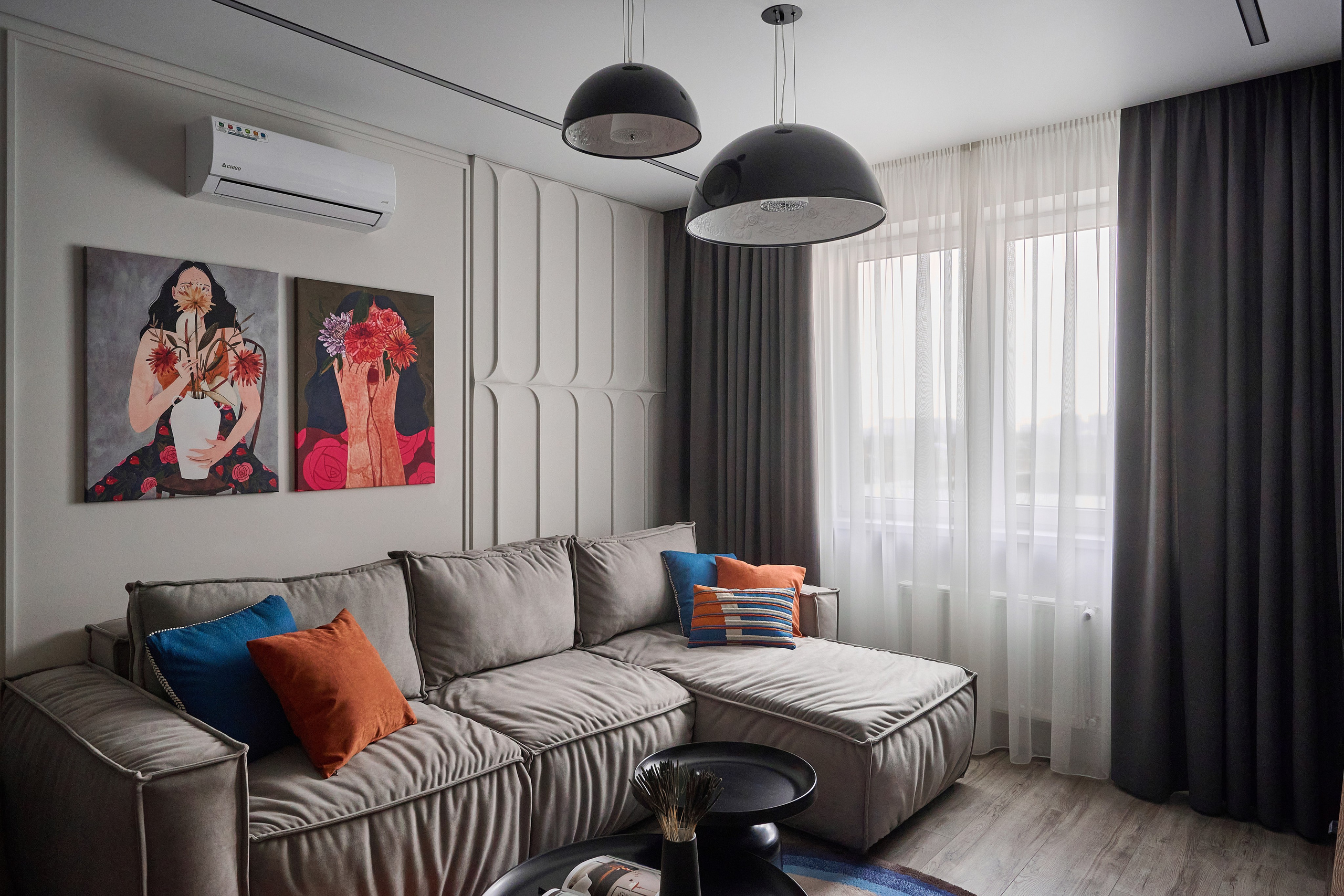 темно светлые оттенки черные шторы коричневый диван с оранжевыми и голубыми подушками черная люстра 