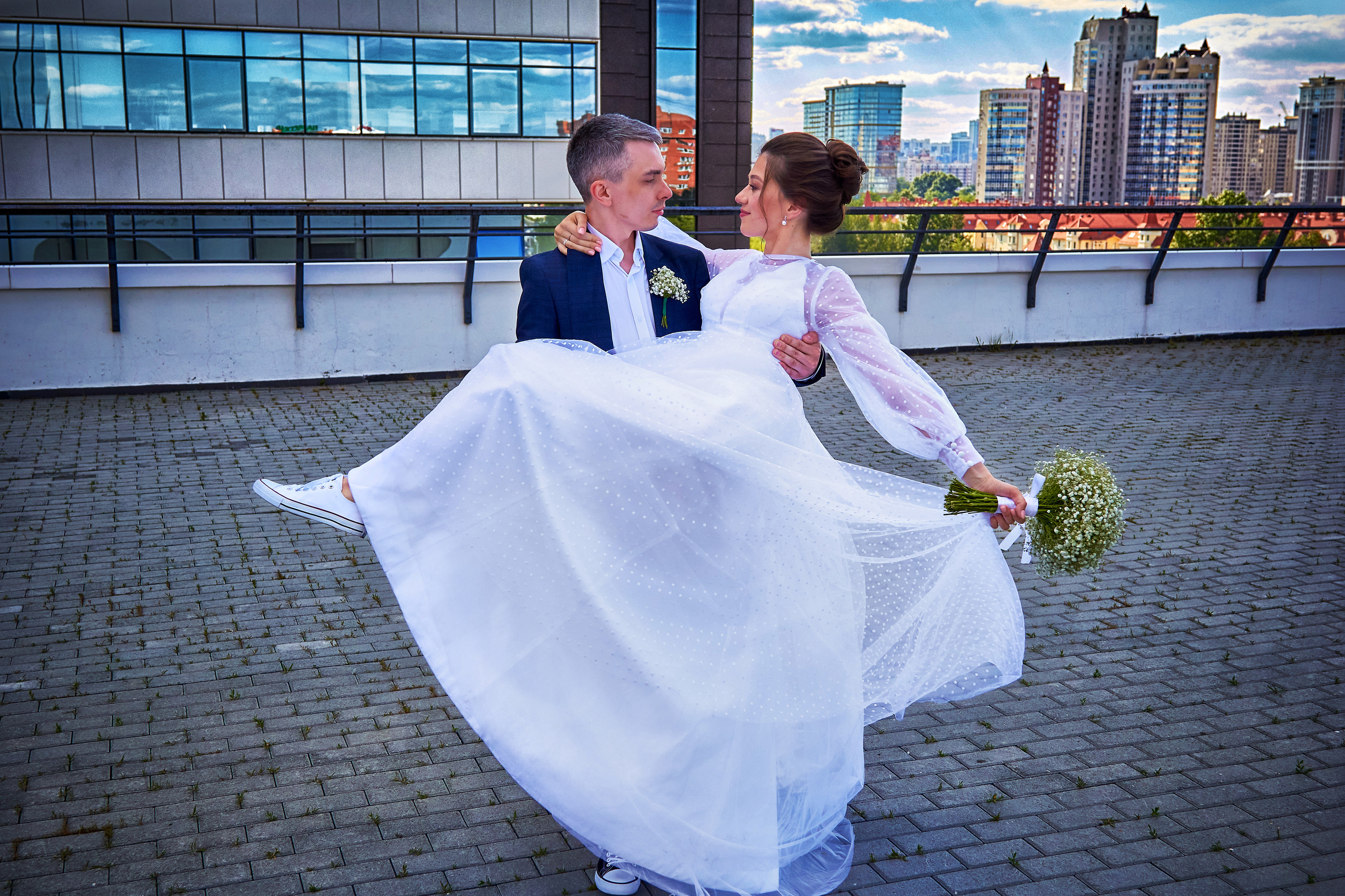 Жених держит невесту на руках