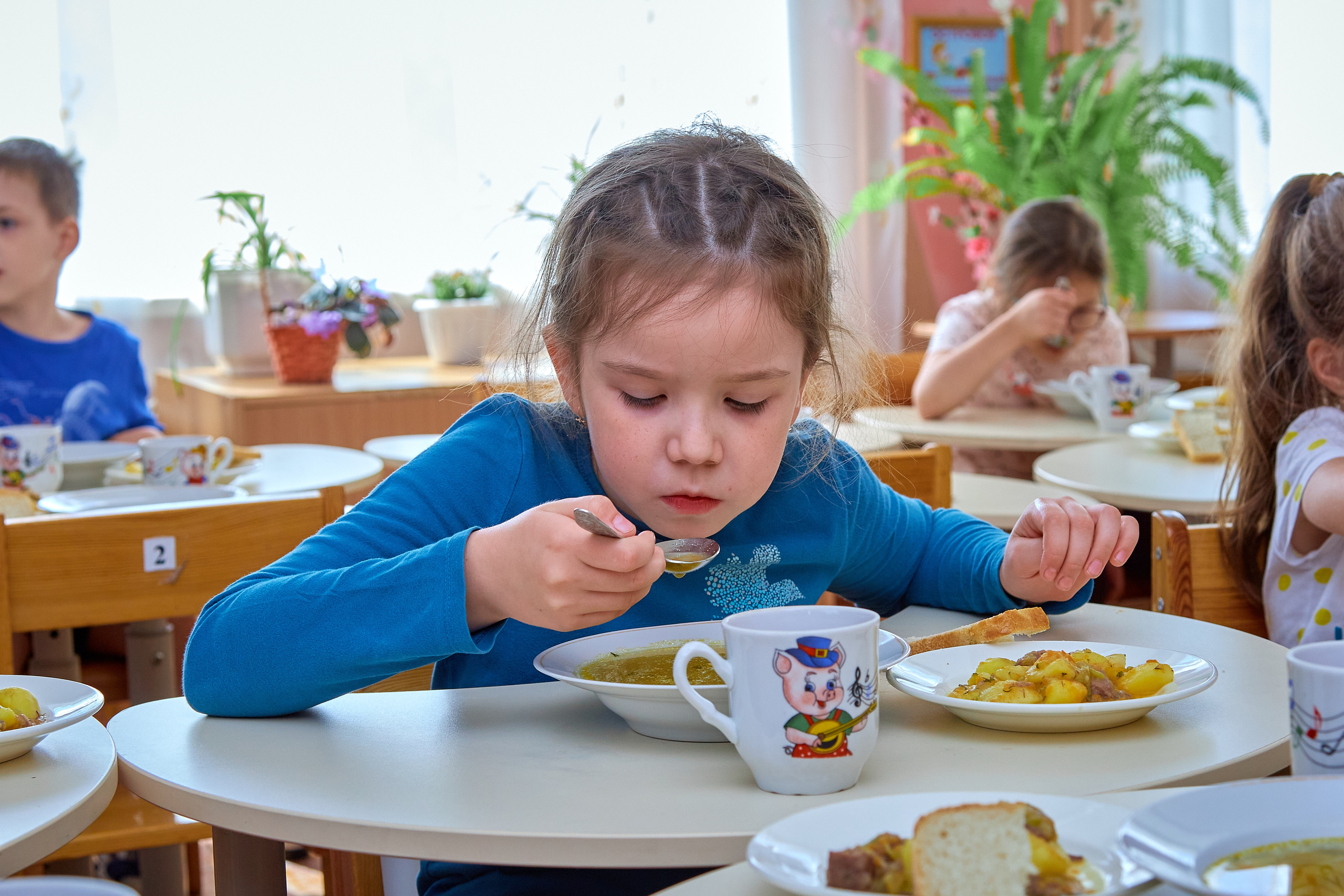 Девочка в детском саду обедает