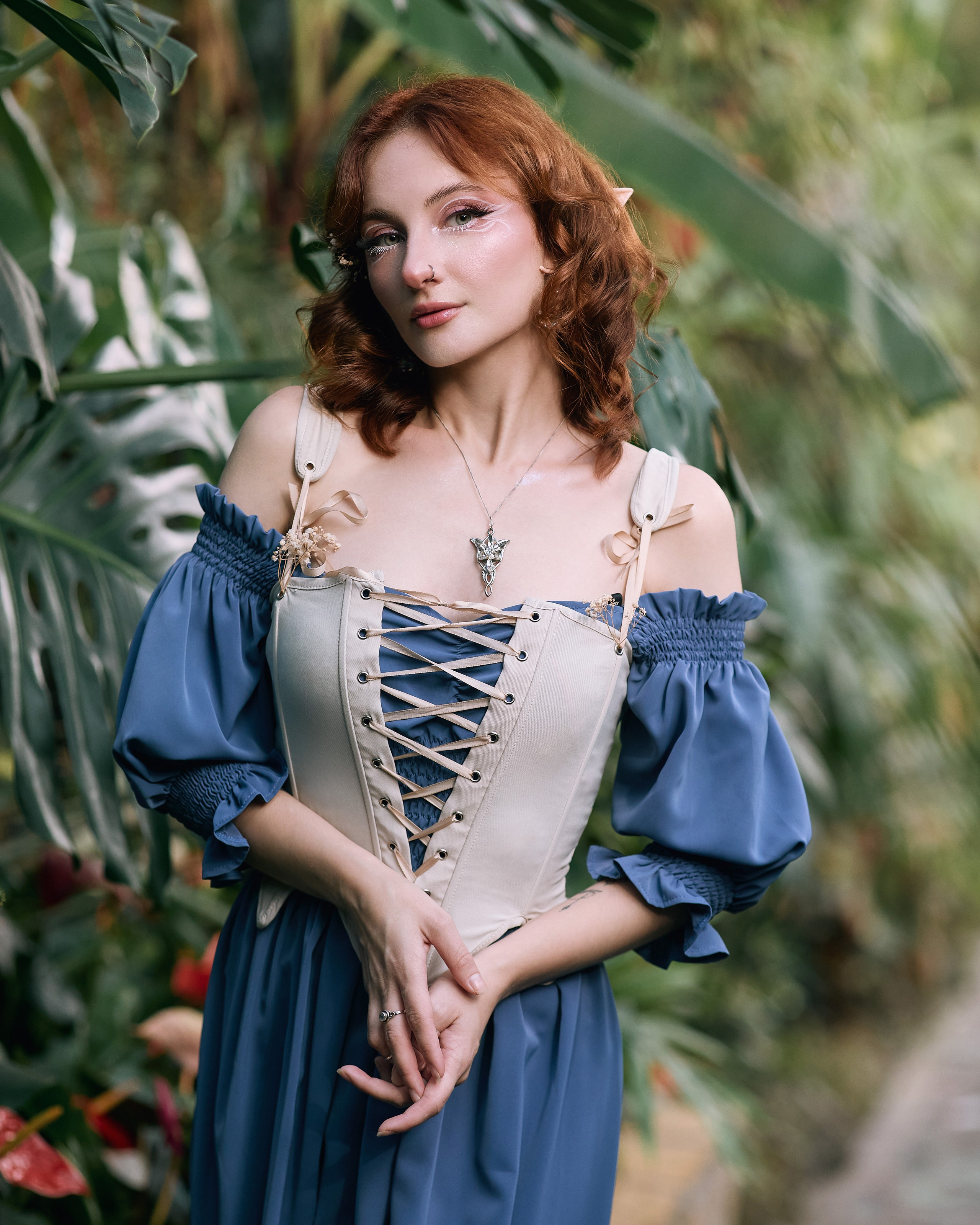 Косплей фотосессия в Ботаническом саду с девушкой в синем платье, белом корсете, белыми узорами на лице