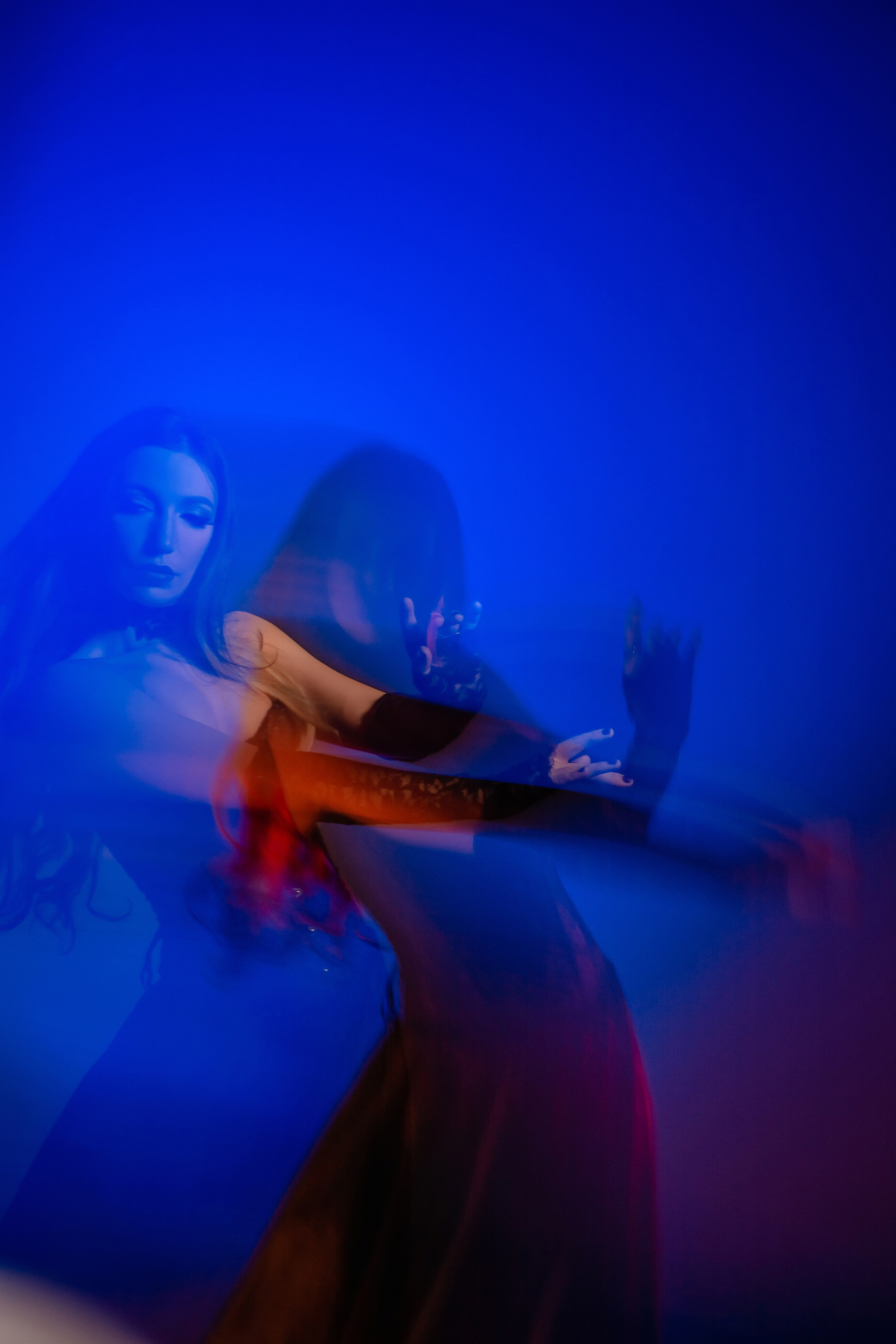 Игра цветов и света: лирическая девушка, окутанная смешанными оттенками красного, синего, бирюзового и розового света