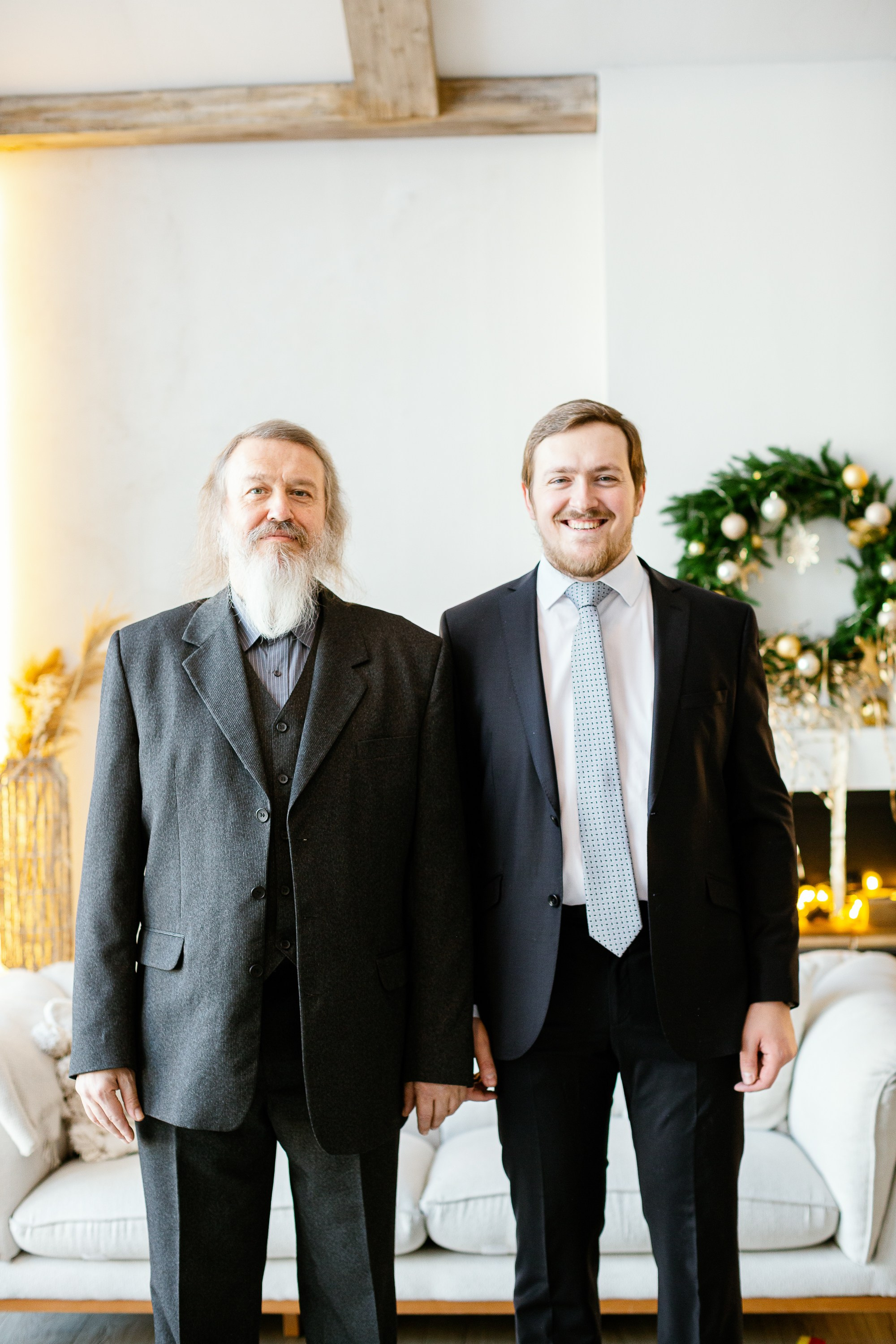 Отец с сыном в праздничной фотостудии стоят.