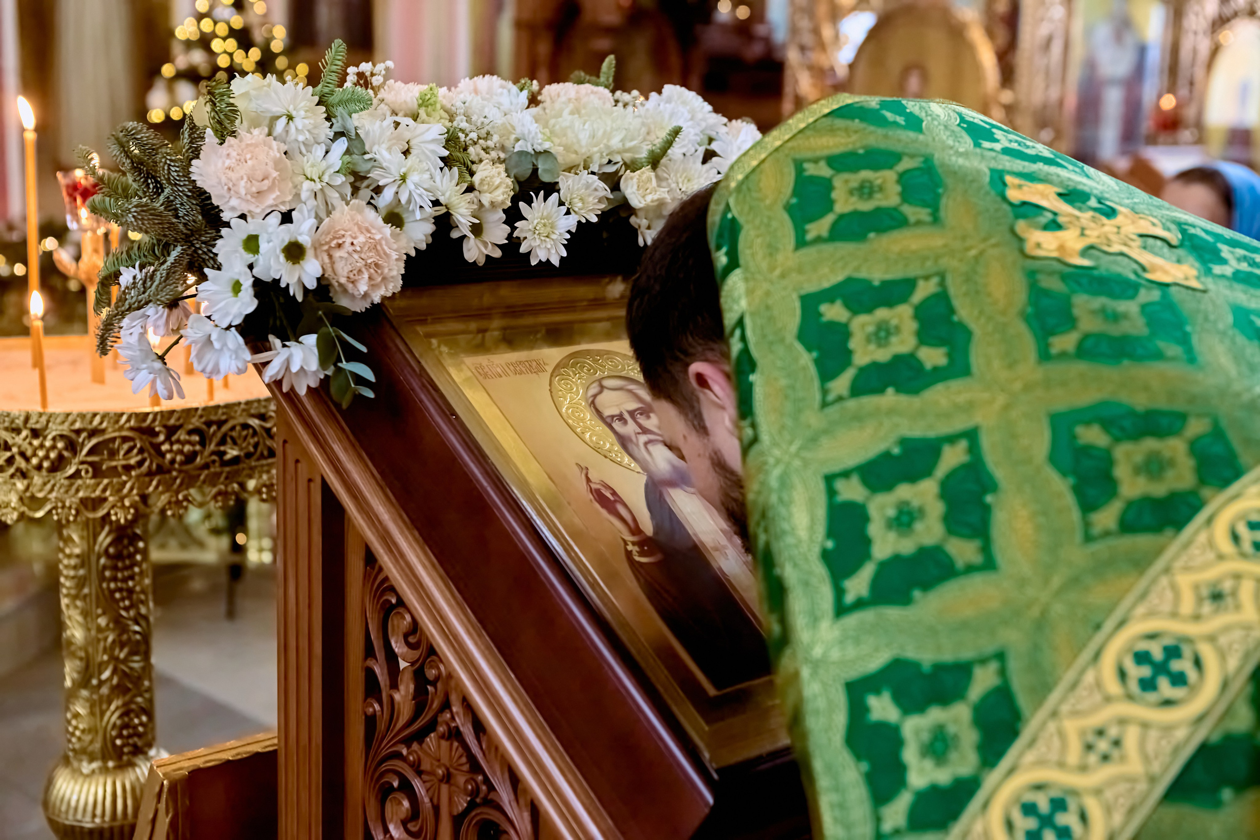 Священник преклоняет голову пред иконой и лобзает (целует) саму икону 