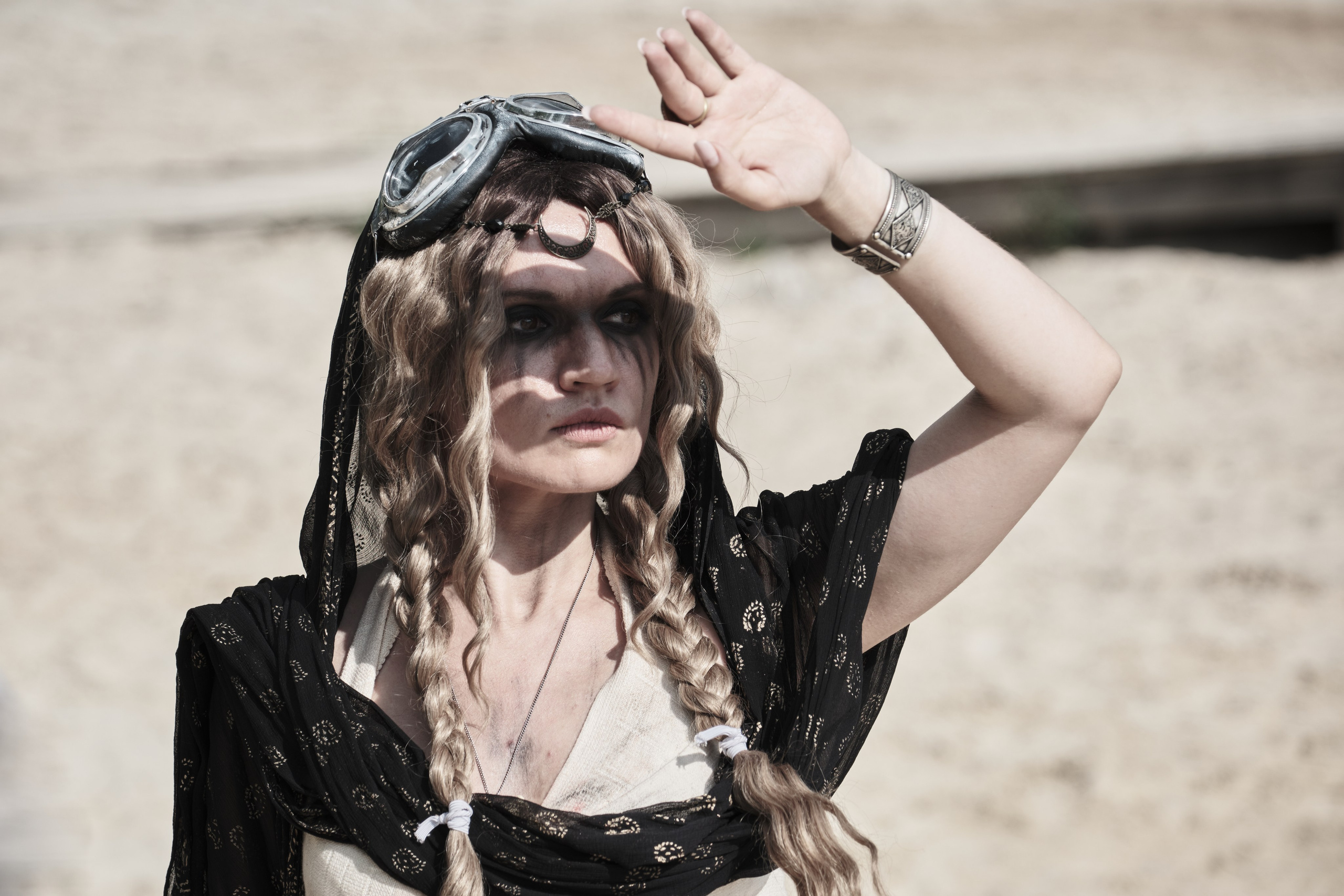 Девушка в костюме пост апокалипсис прикрывает солнце рукой