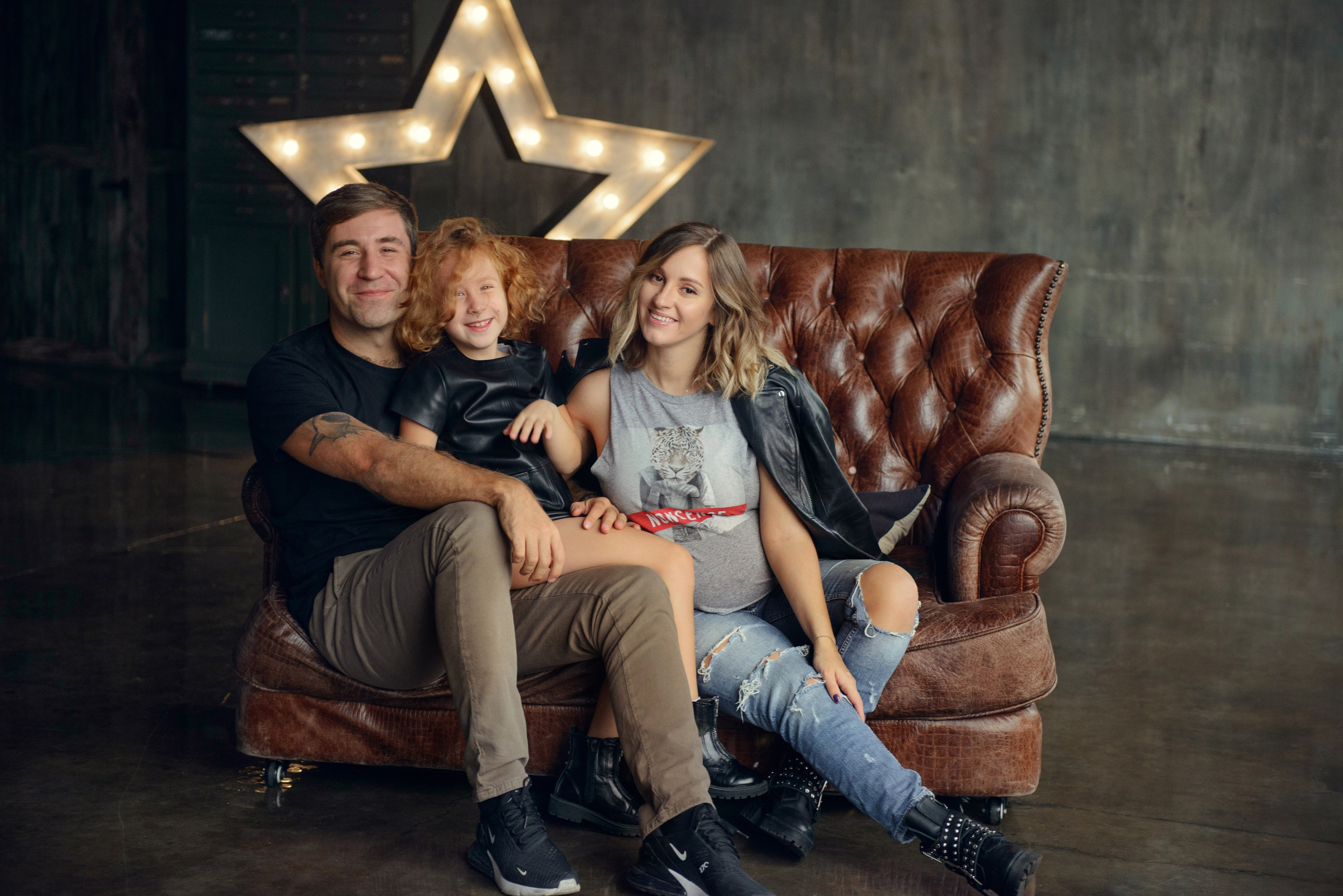 Family photo shoot with a pregnant woman in a loft studio, rock and roll style