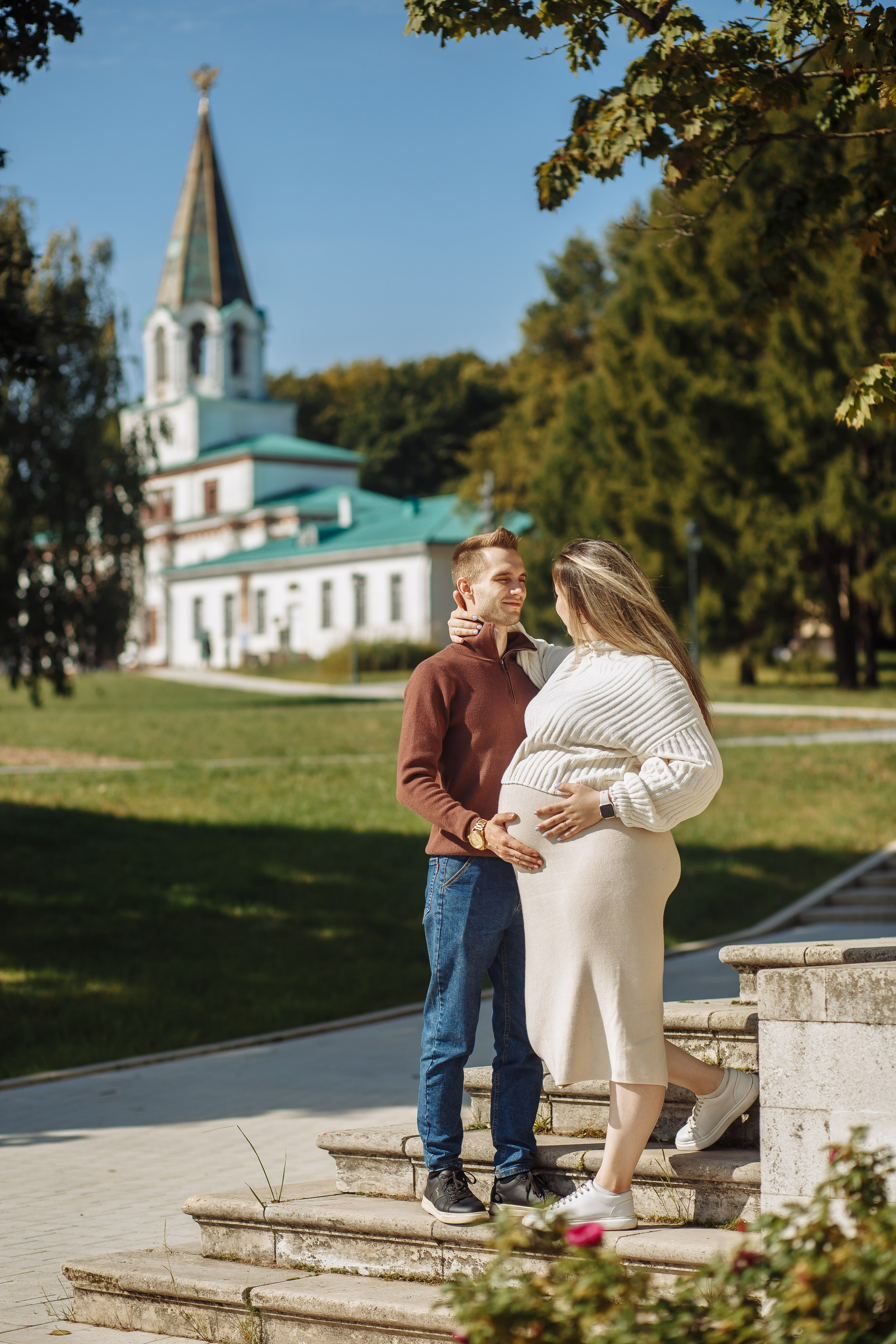 Муж и беременная жена на прогулке с фотографом на фоне комплекса передних ворот в парке-музее Коломенское. Куда сходить в Москве с фотографом: https://foto-video-svadba.ru/kuda-shodit-v-moskve 