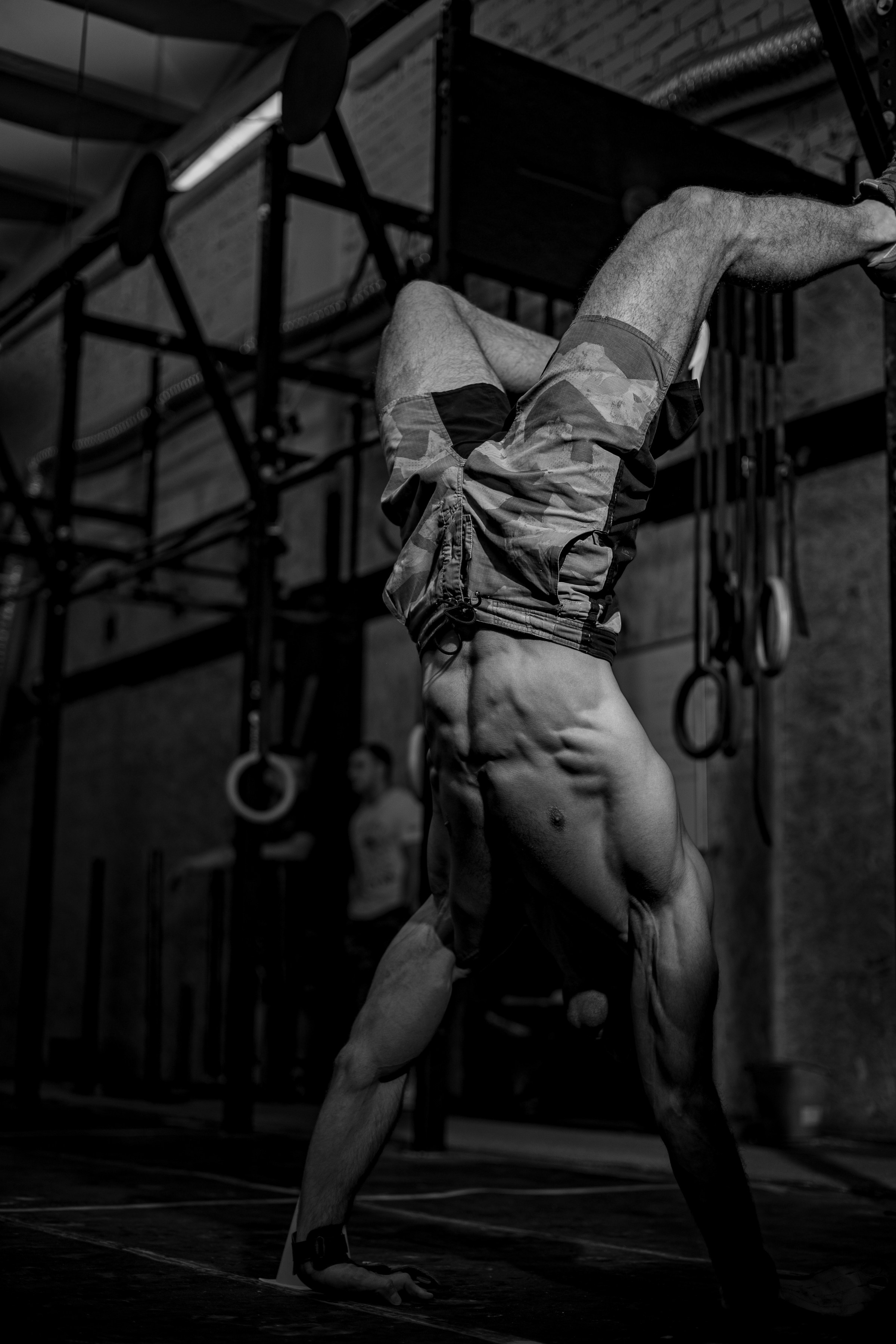 Черно-белая фотография спортсмена стоящего на руках с напряженным прессом Кемерово Functional Training MINE