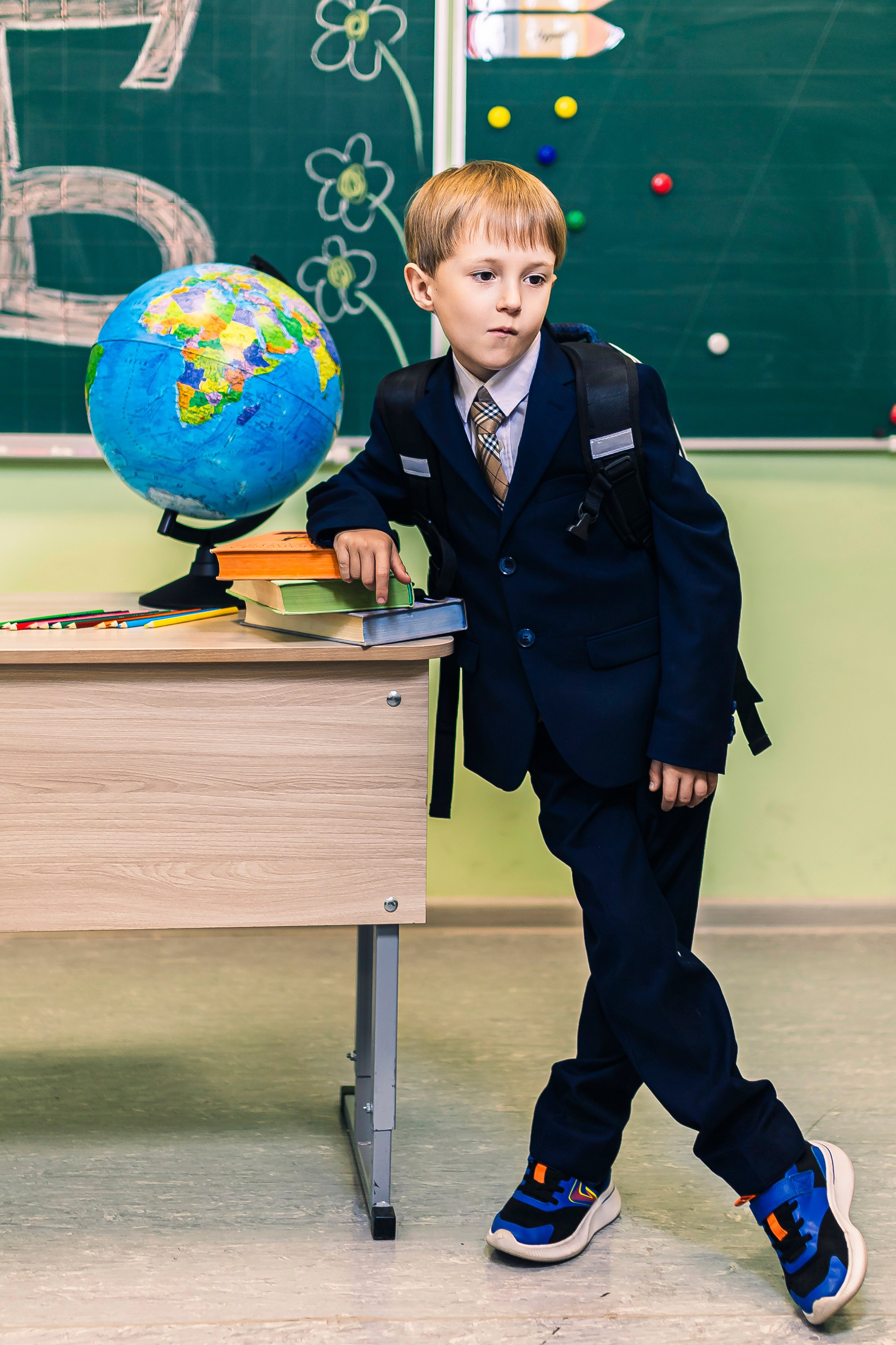 школьник стоит около парты 