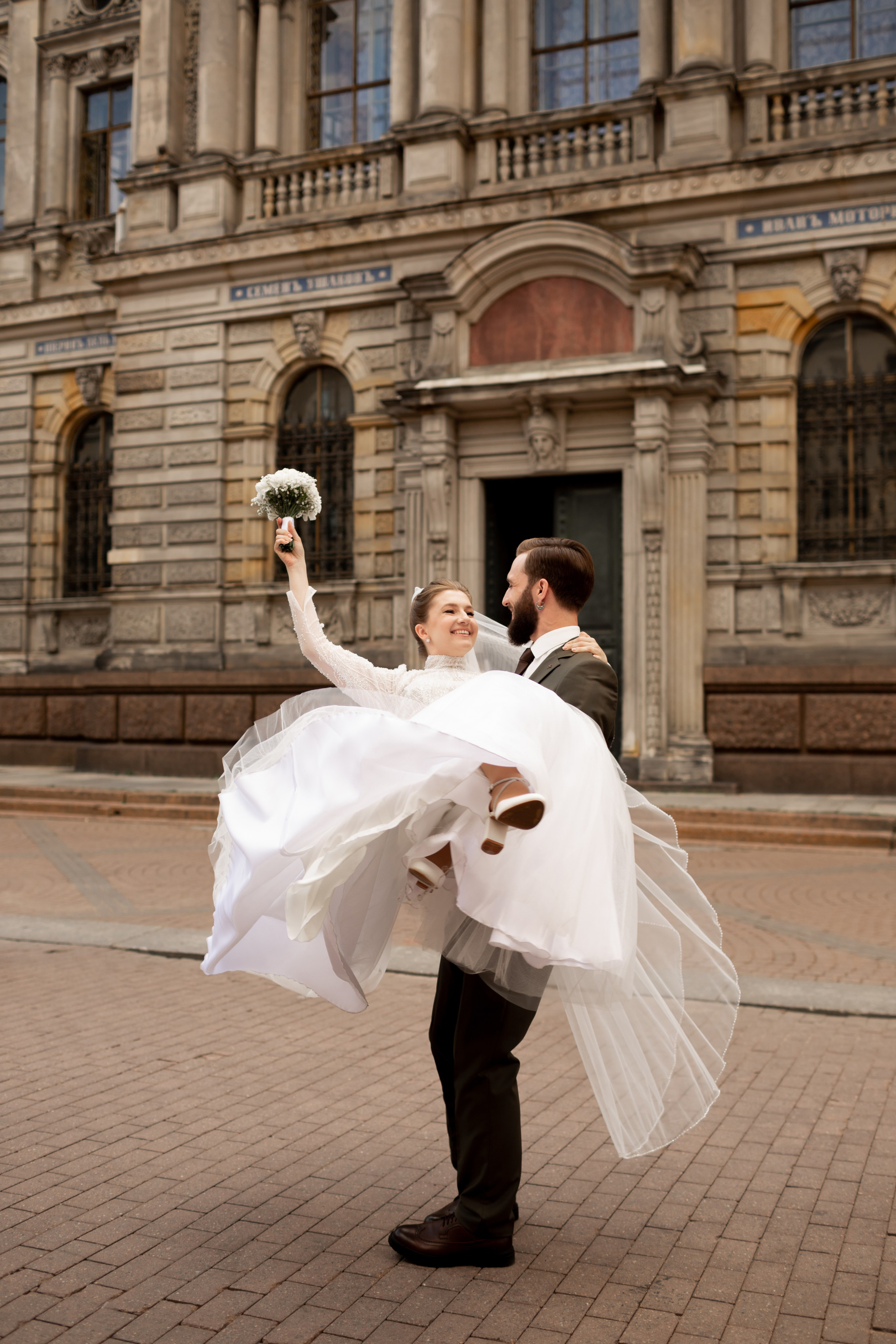 Счастливый жених кружит невесту на руках около академии Штиглица