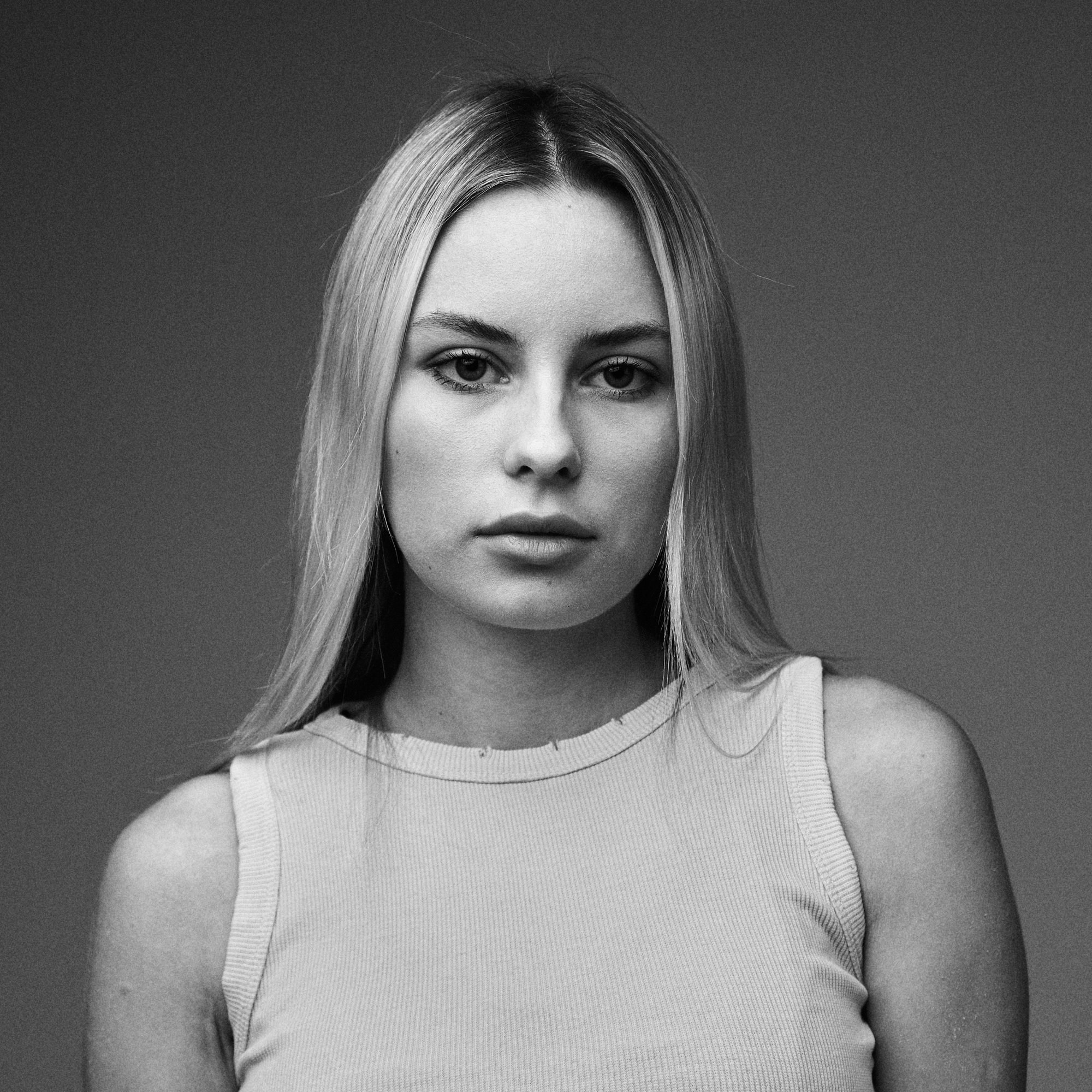 Чёрно-белый портрет девушки с длинными волосами, студийный фон