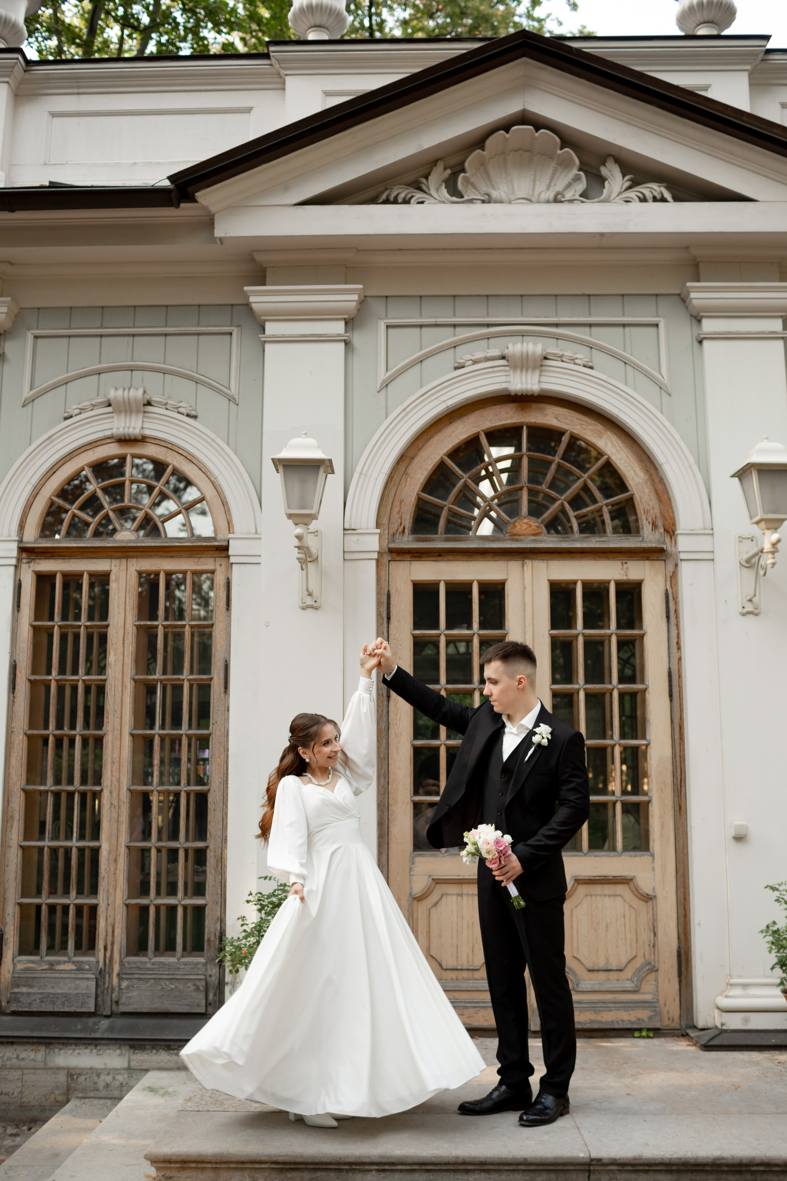 Эстетичная свадебная фотография: жених кружит невесту в Летнем саду.