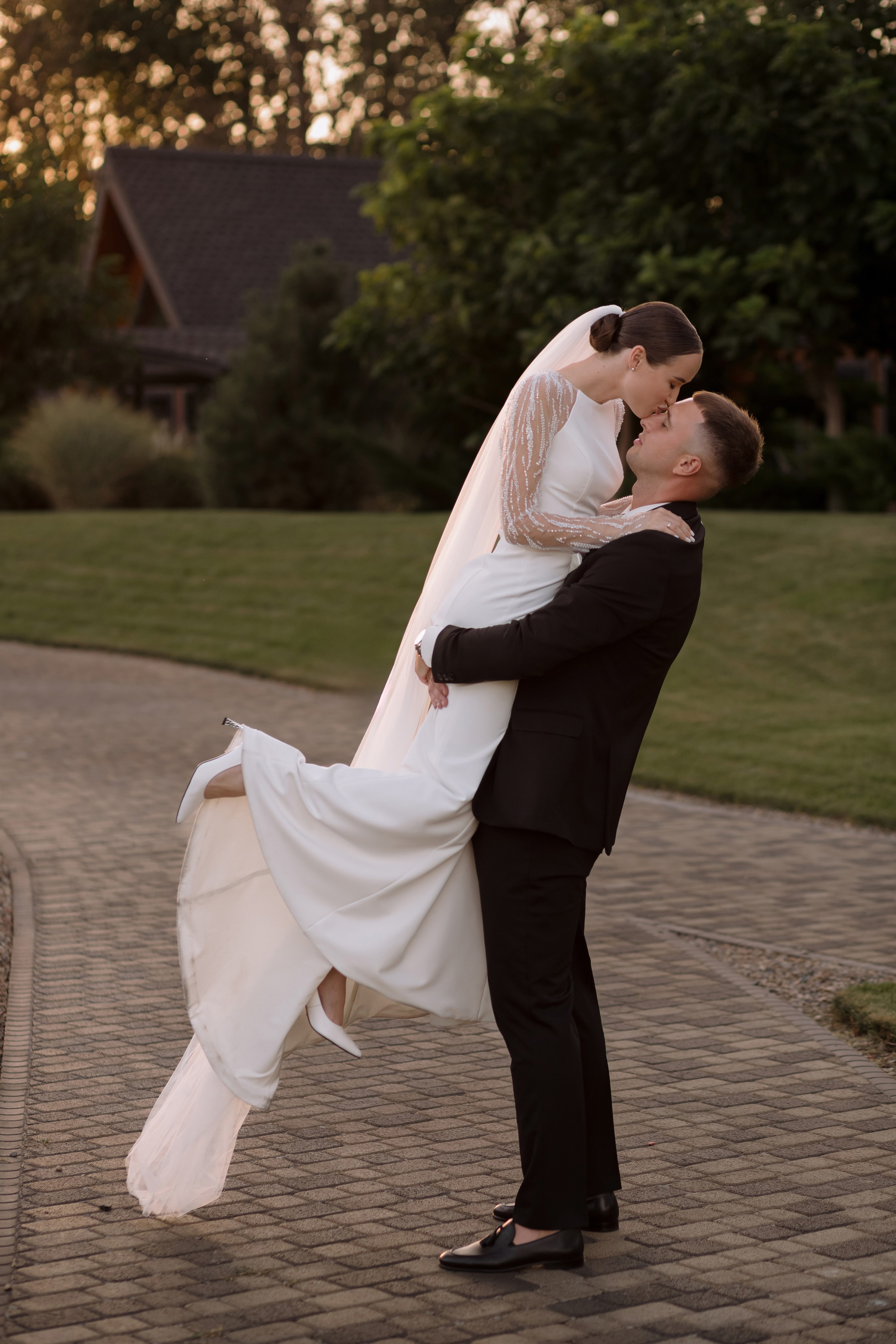 Жених поднимает невесту на руках во время свадебной прогулки в Таганроге