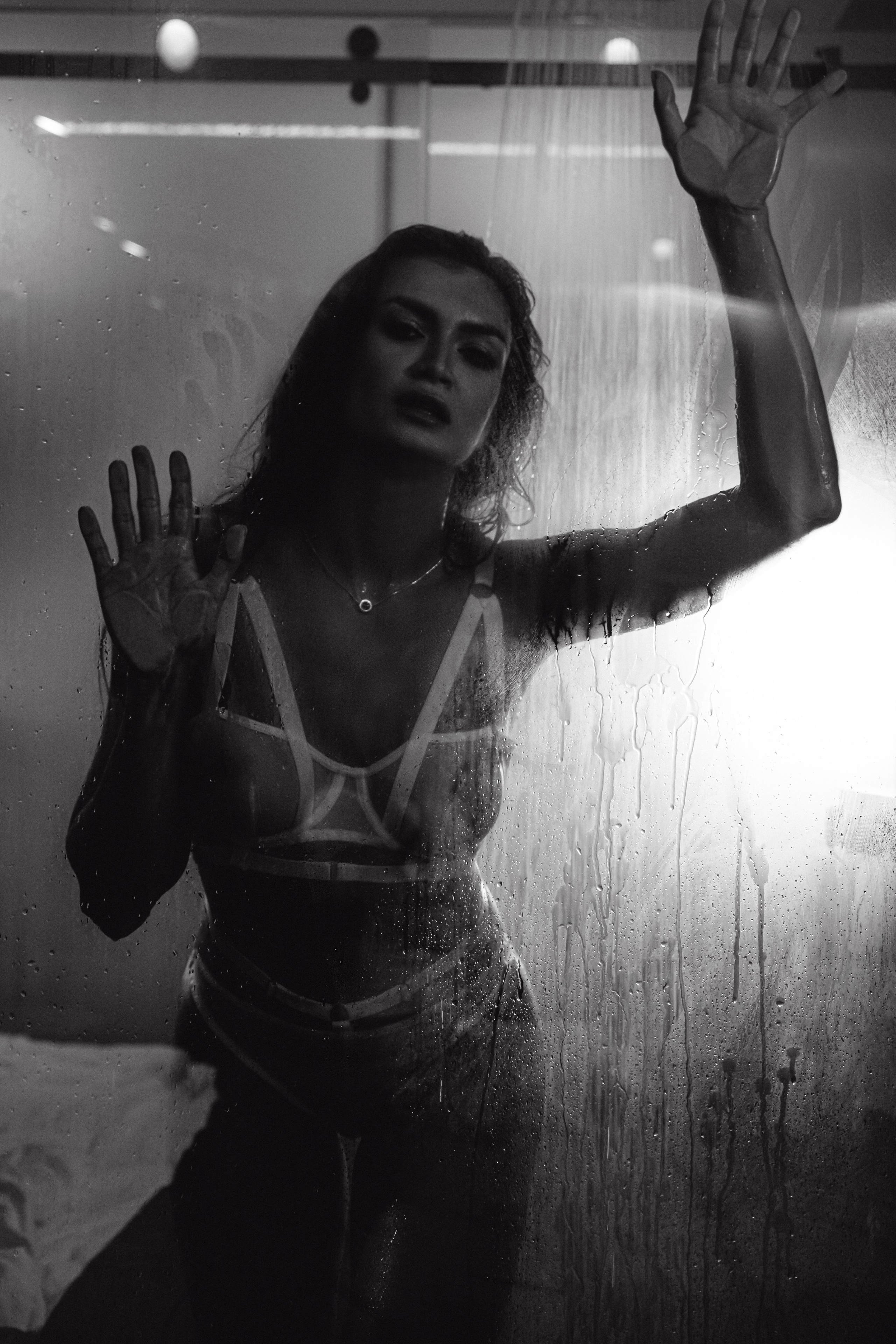  "Изящная силуэтная фигура девушки, застекленная в душе с капельками воды, создает загадочный и привлекательный образ."