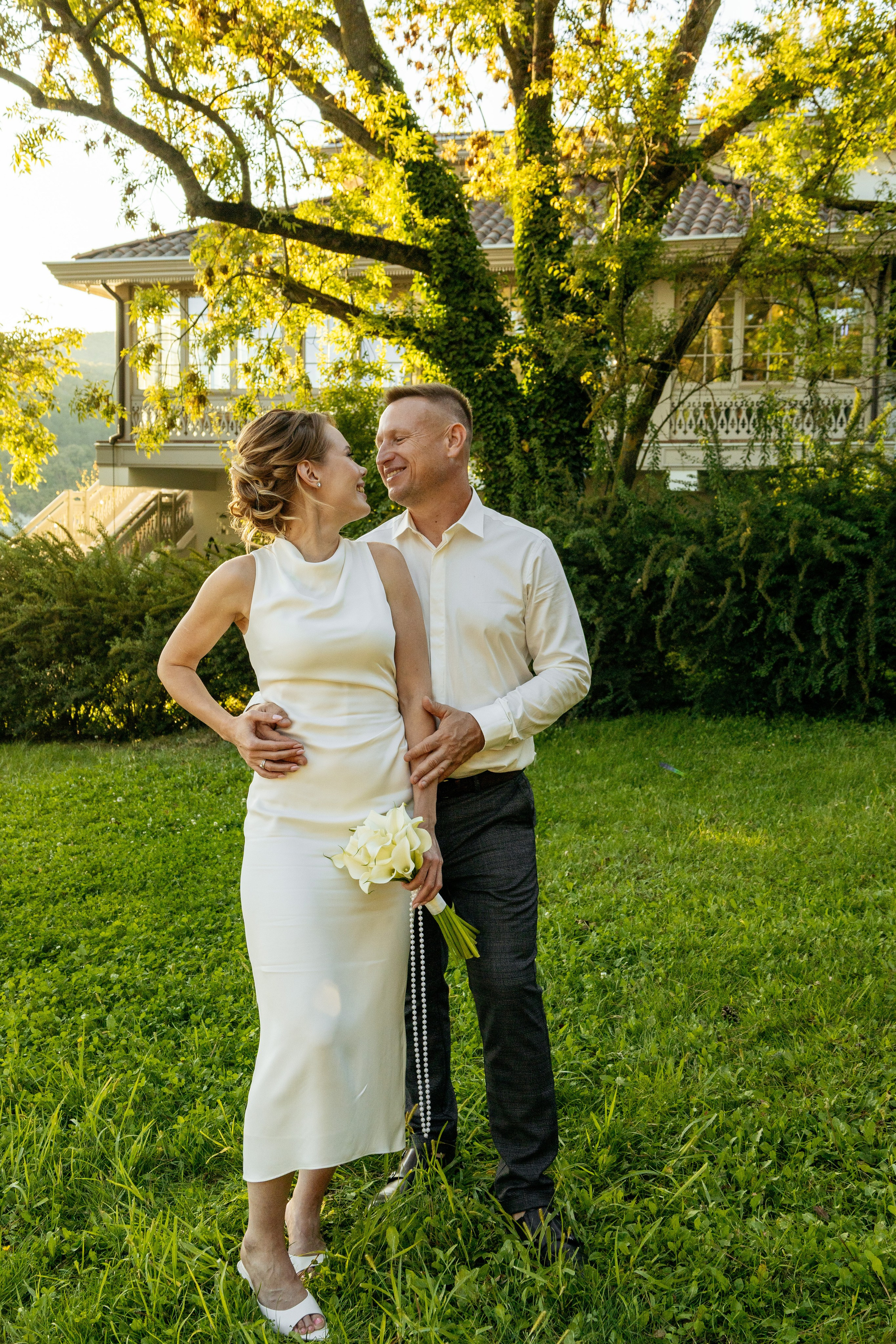 Невеста и жених бегут по цветущему лугу в Абрау-Дюрсо