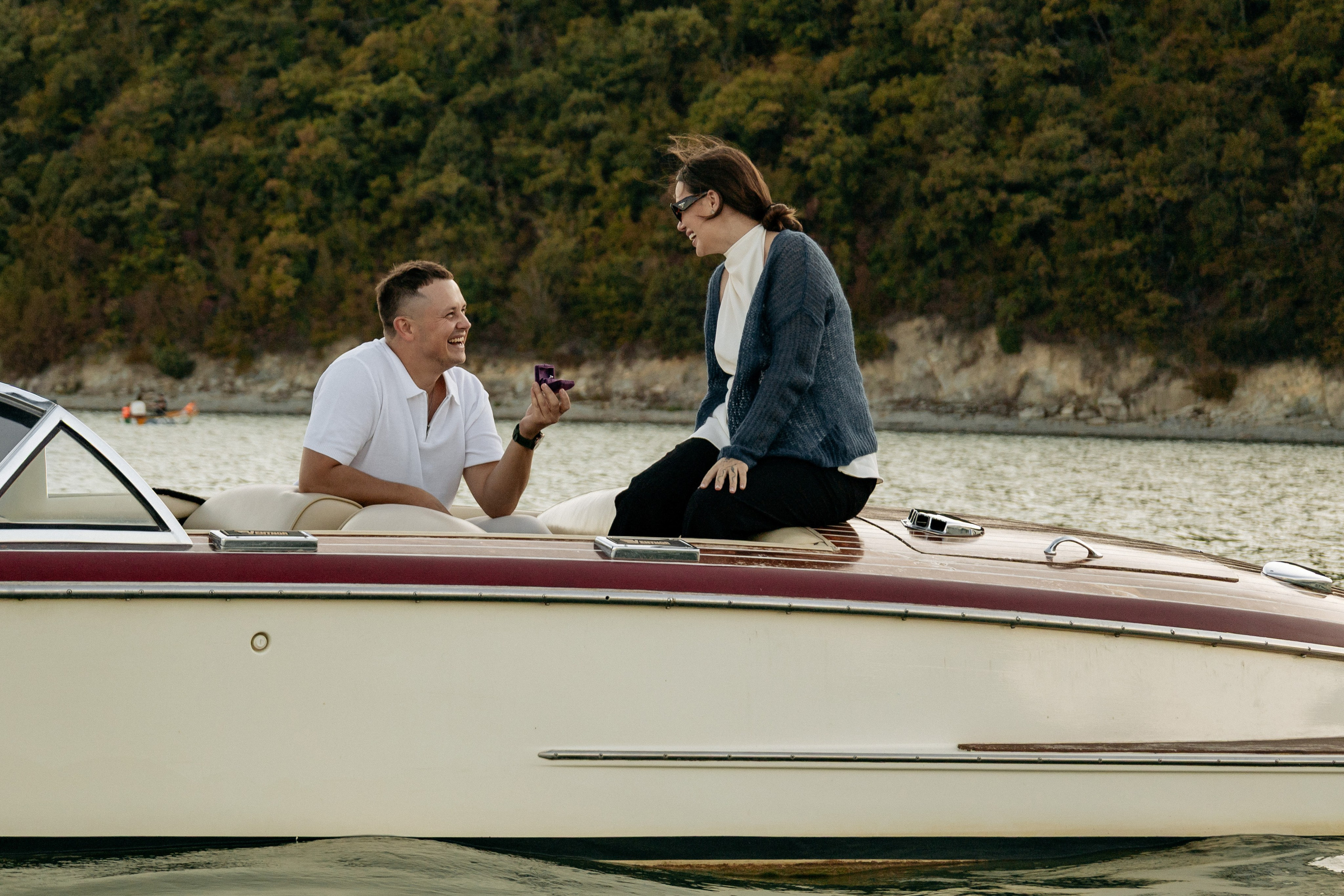 Объятия и улыбки во время прогулки на лодке по озеру