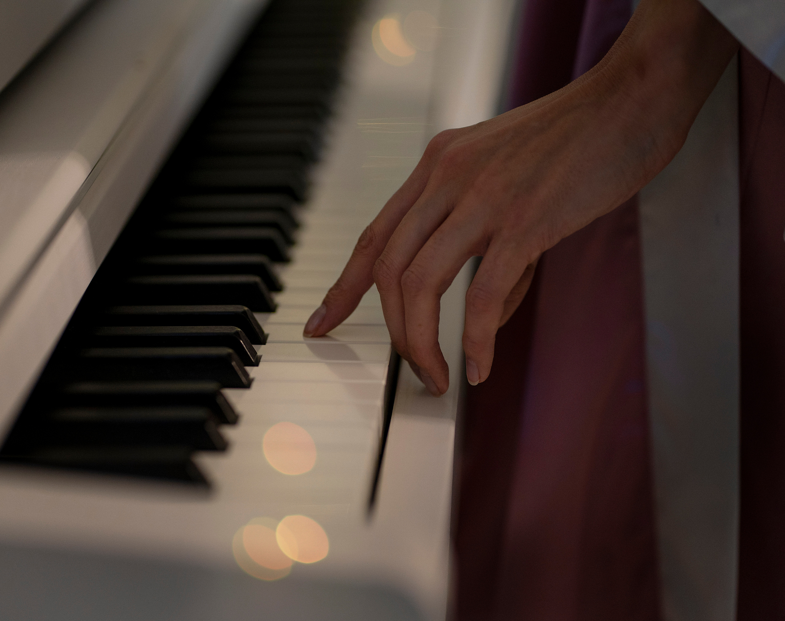 Женская рука пробегает по клавишам пианино. Вечер. Мигают гирлянды.