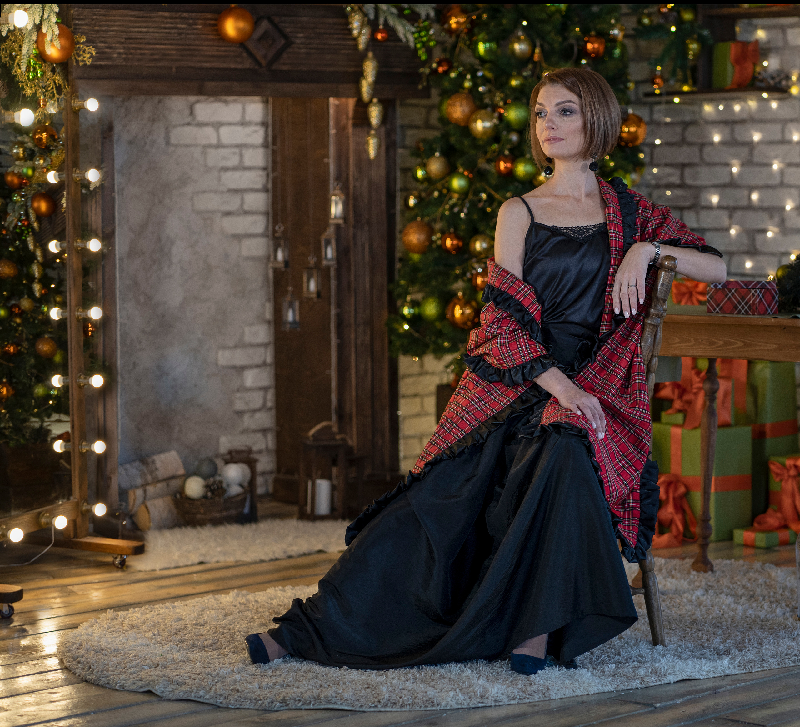 Женщина в вечернем платье у камина. Новогодний интерьер.