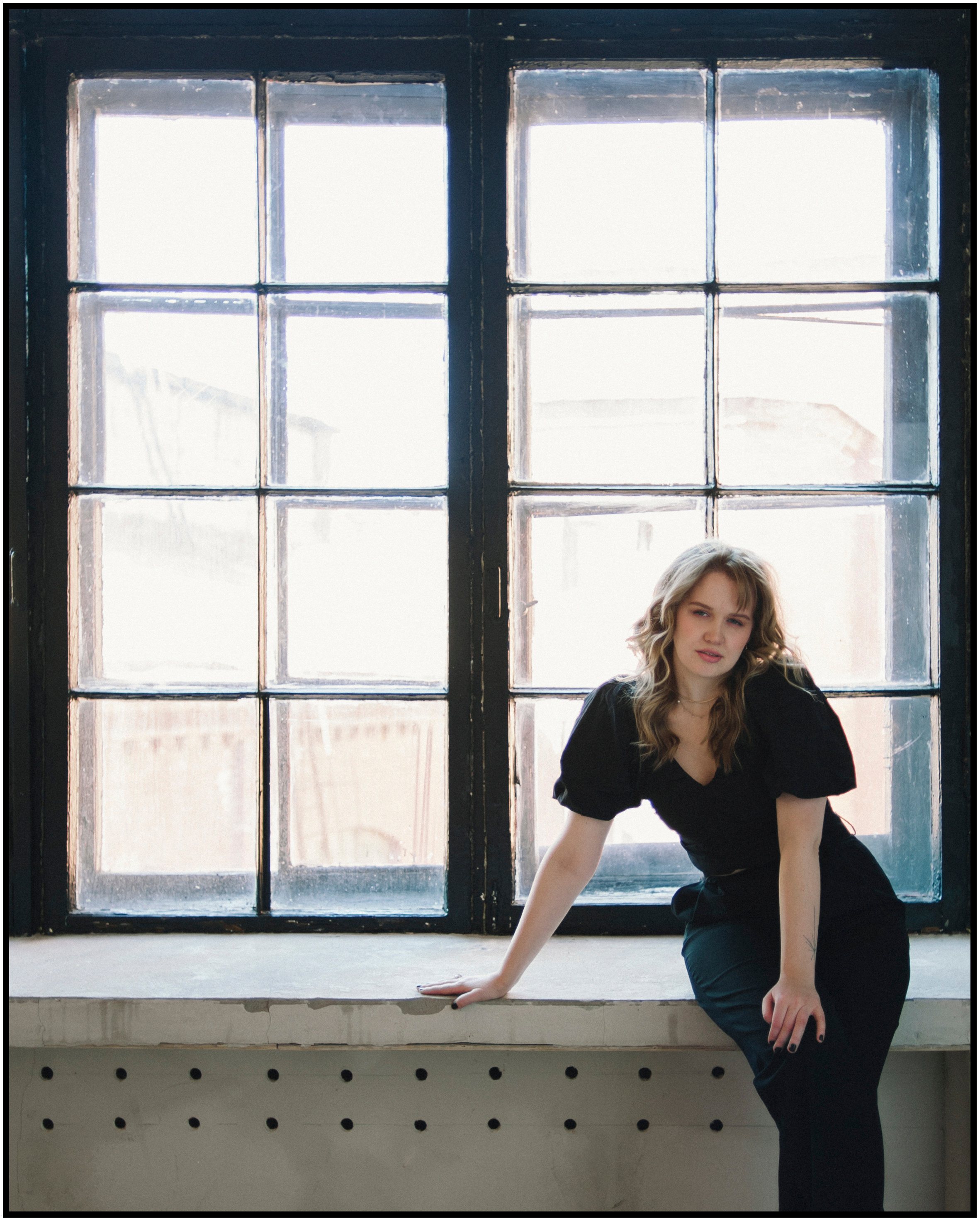 Портрет девушки на фоне окна в фотостудии