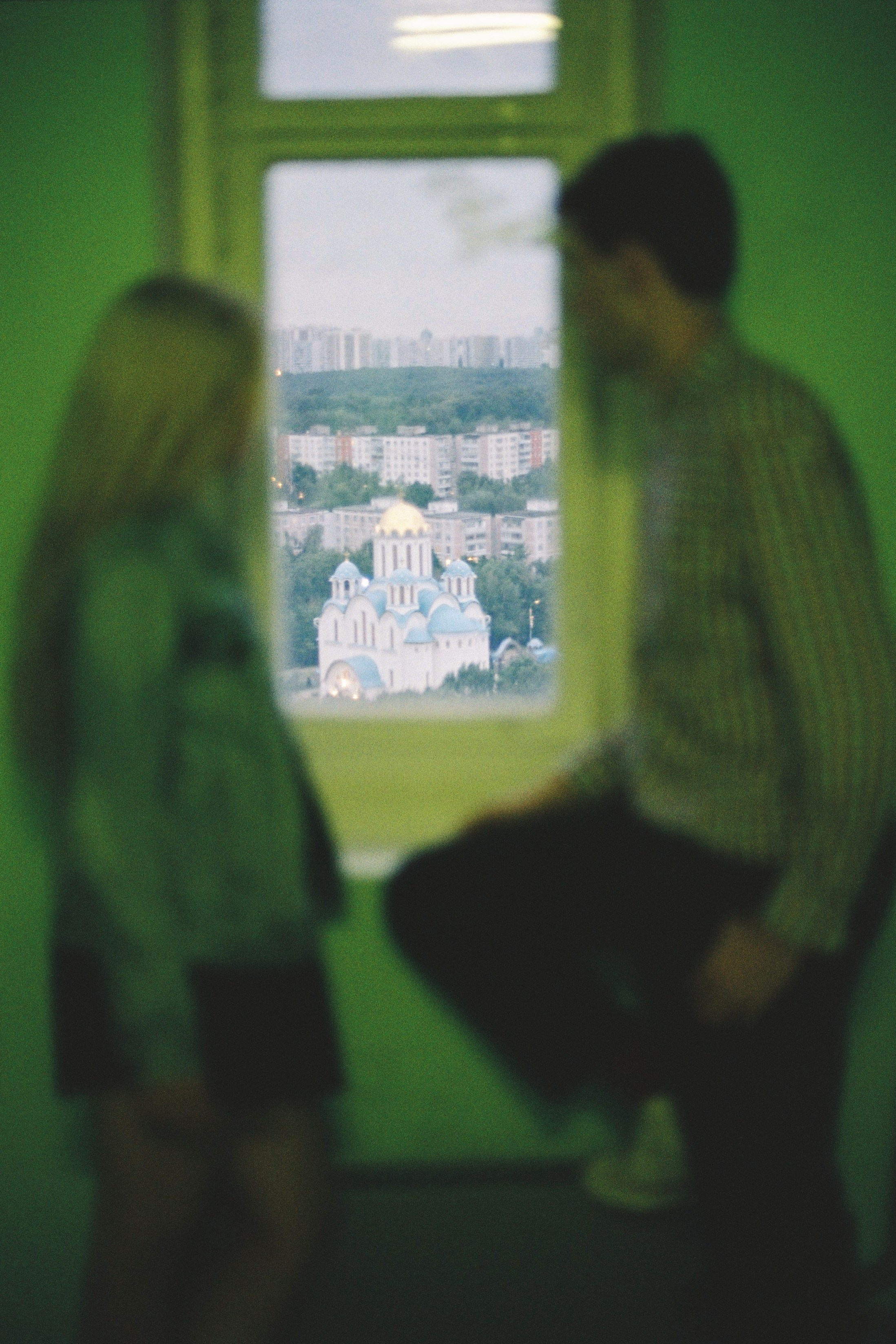 Парень с девушкой стоят у окна и смотрят в него на храм