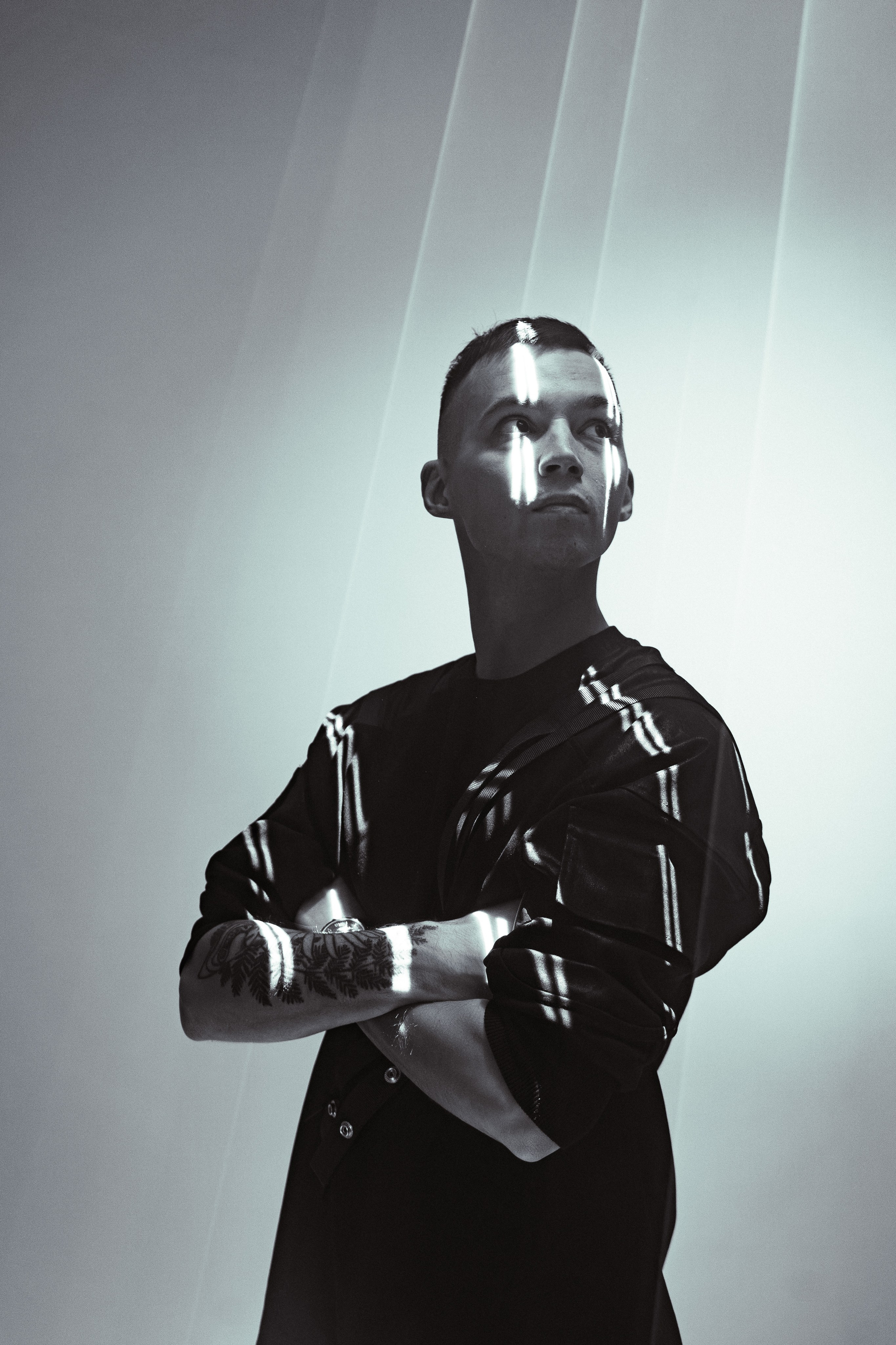 Мужчина смотрит наверх, окруженный яркими лазерными линиями