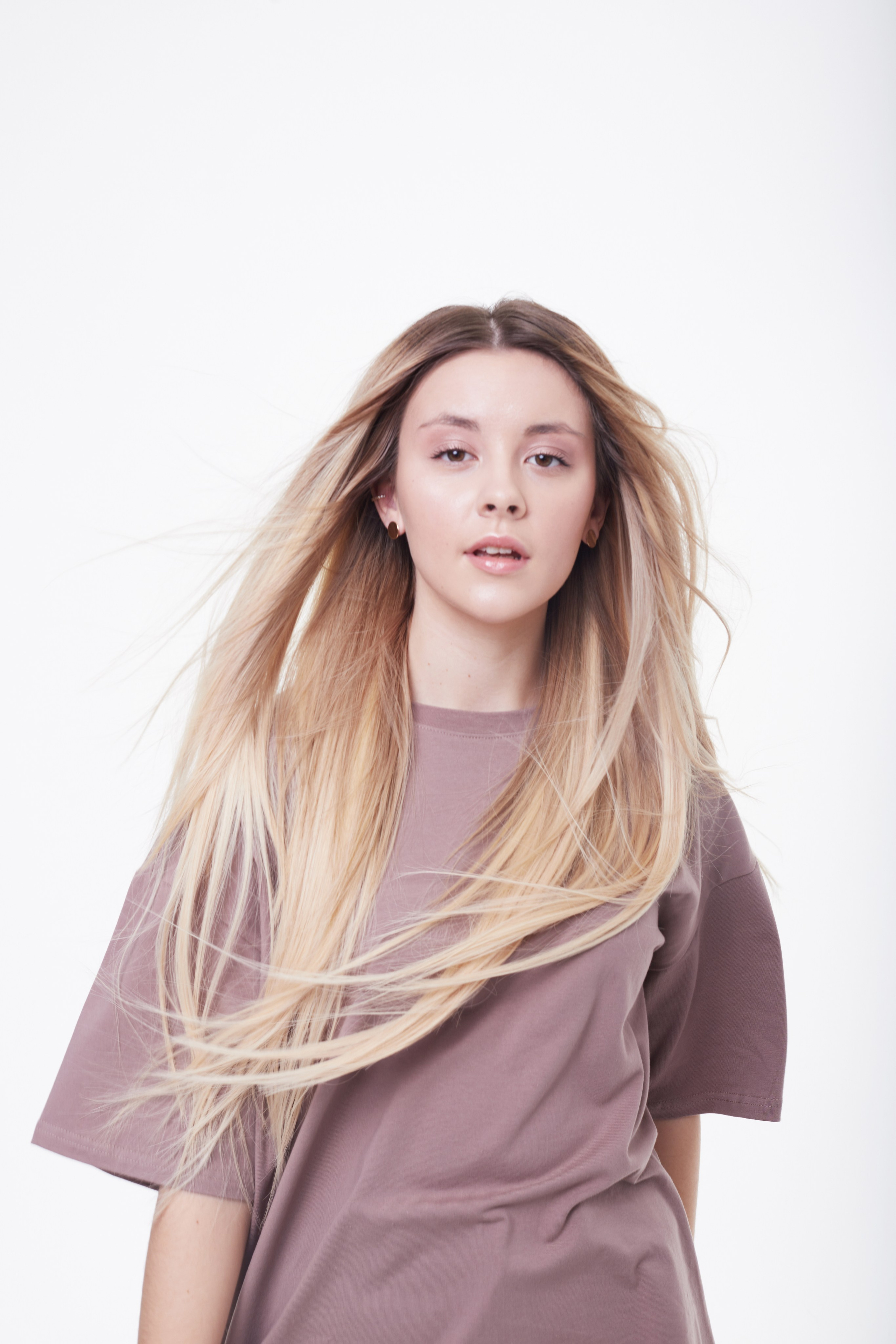 Студийный портрет девушки с длинными волосами в движении.