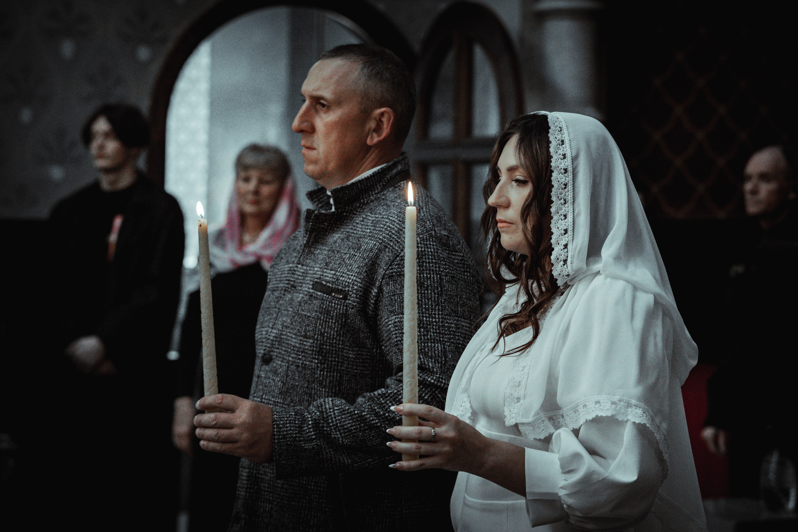 Жених и невеста со свечами во время венчания, тёмный храмовый свет — Екатеринбург, Илья Антропов