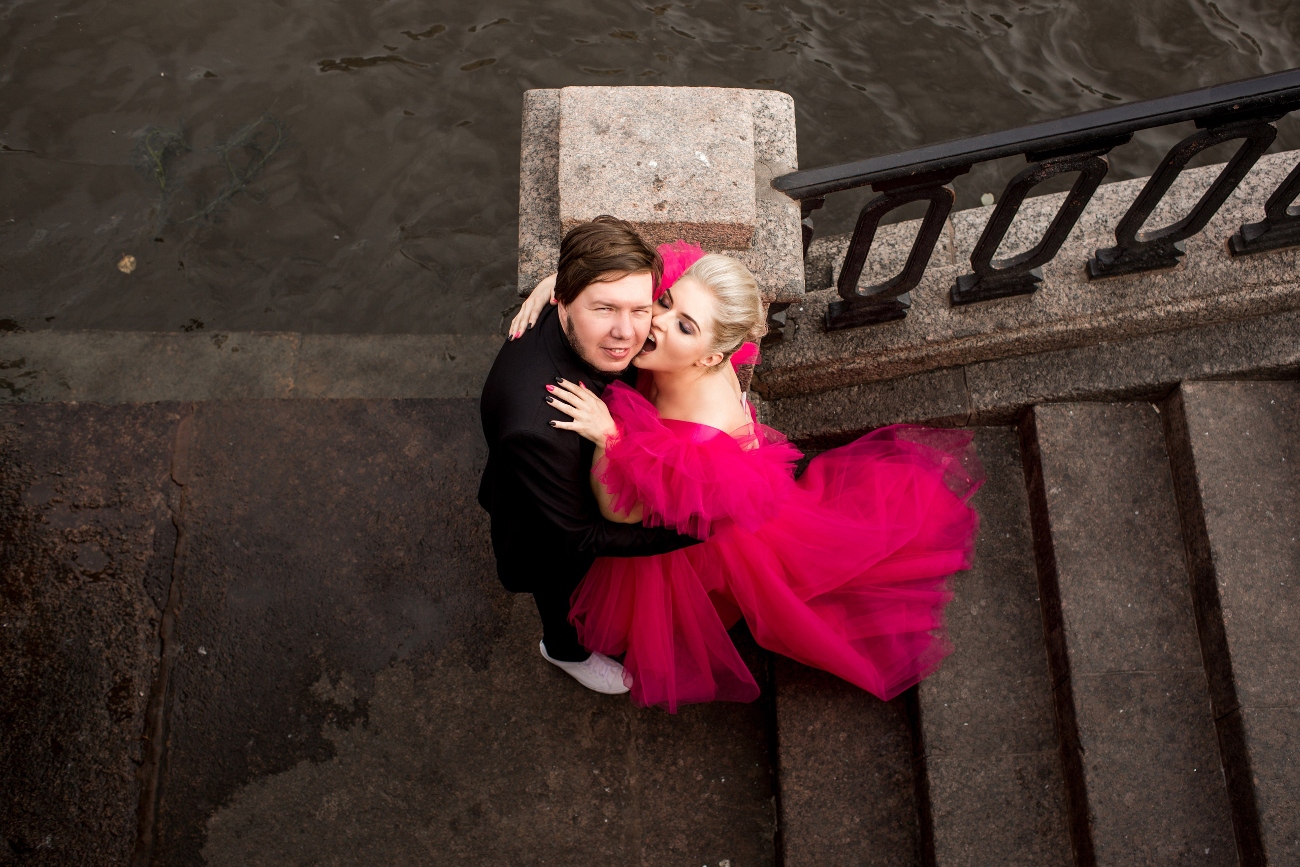 Жених целует невесту в красном свадебном платье — любовь в кадре