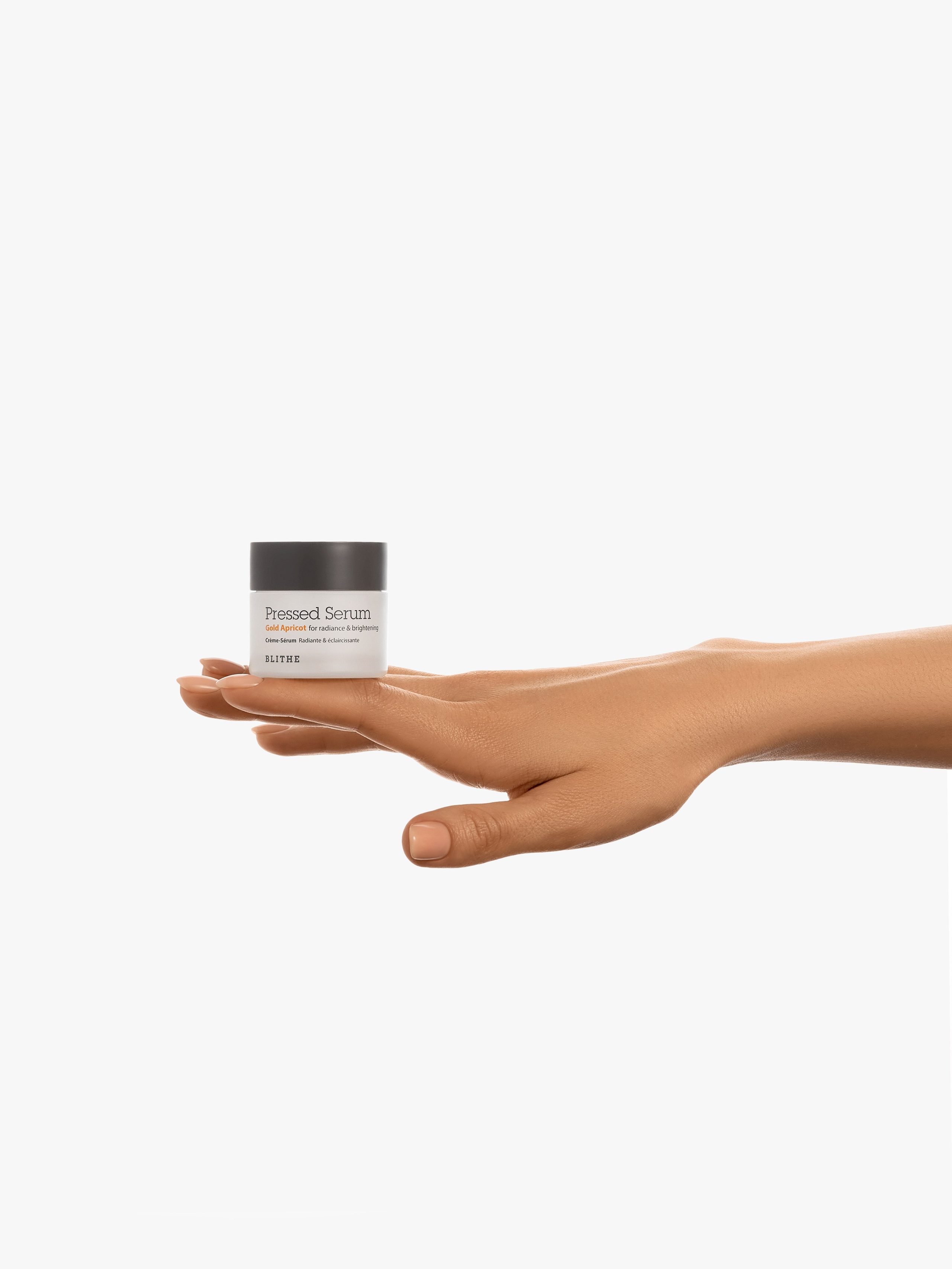 Баночка крема стоит на тыльной стороне ладони девушки