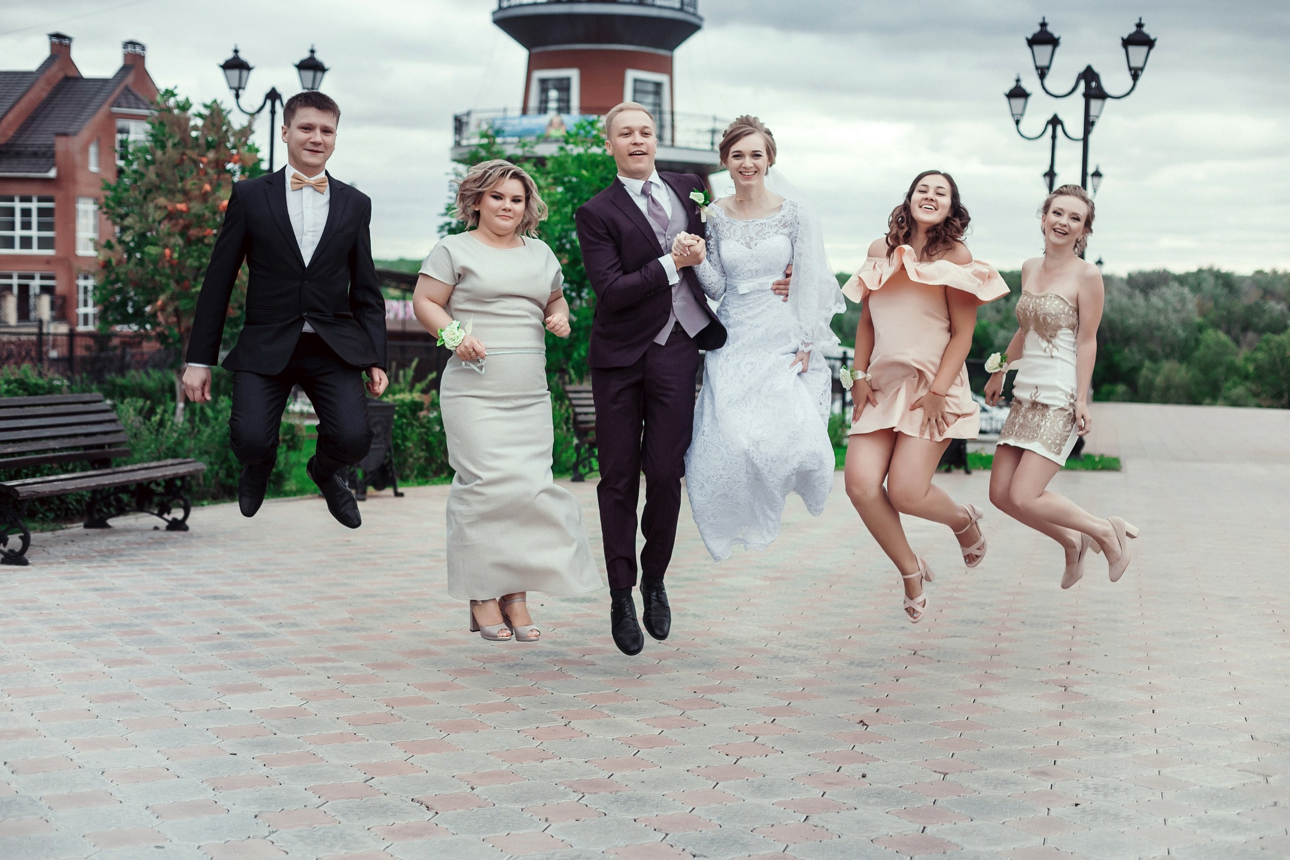 Свадебная съемка. Фотография жениха и невесты с гостями. В прыжке