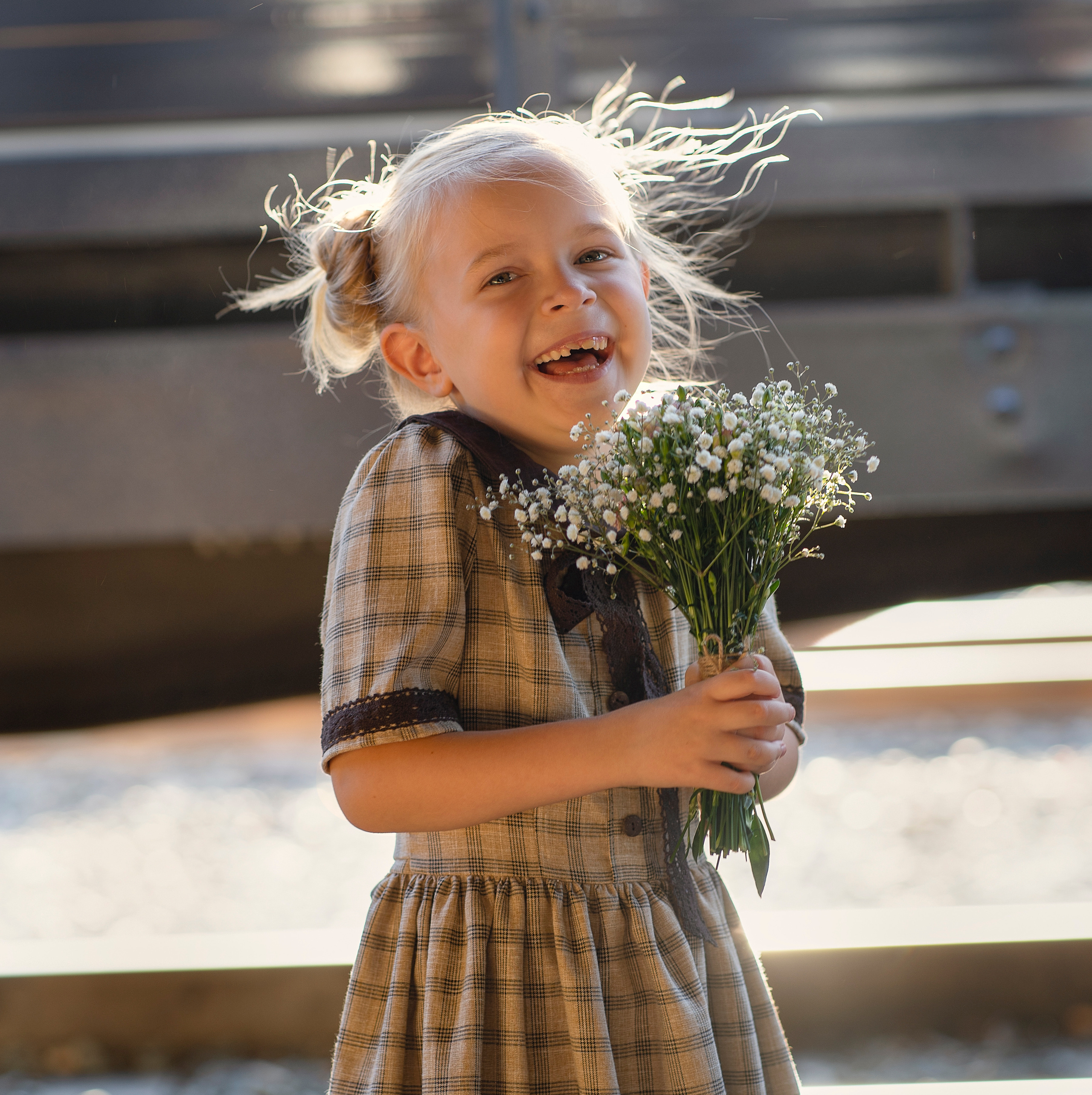 Девочка заразительно смеется на перроне вокзала
